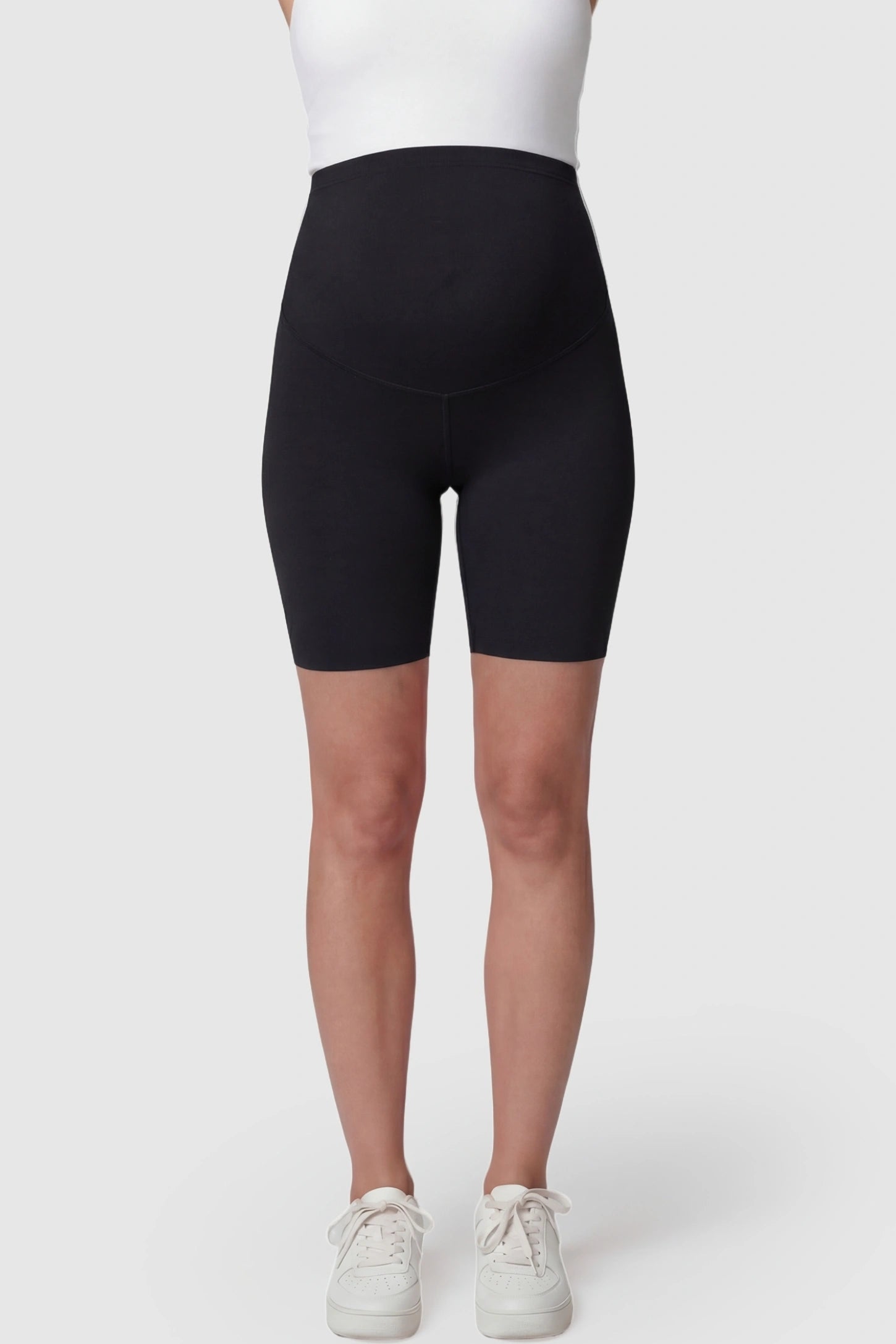 High-waist belly support slim fit shark maternity shorts in black with supportive waistband, front view on pregnant model