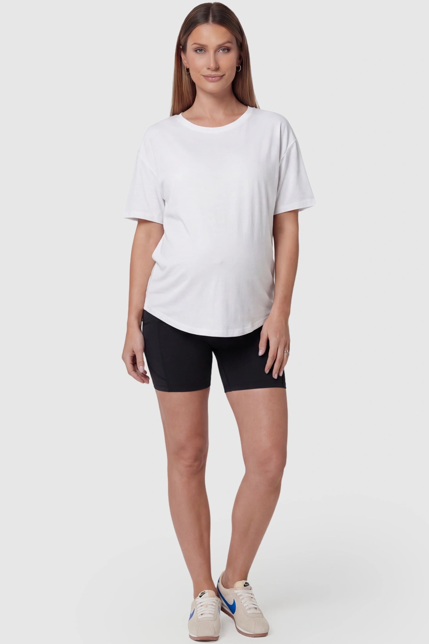 High-waist tummy support body-hugging maternity shorts in black with sculpted fit, full body on pregnant model