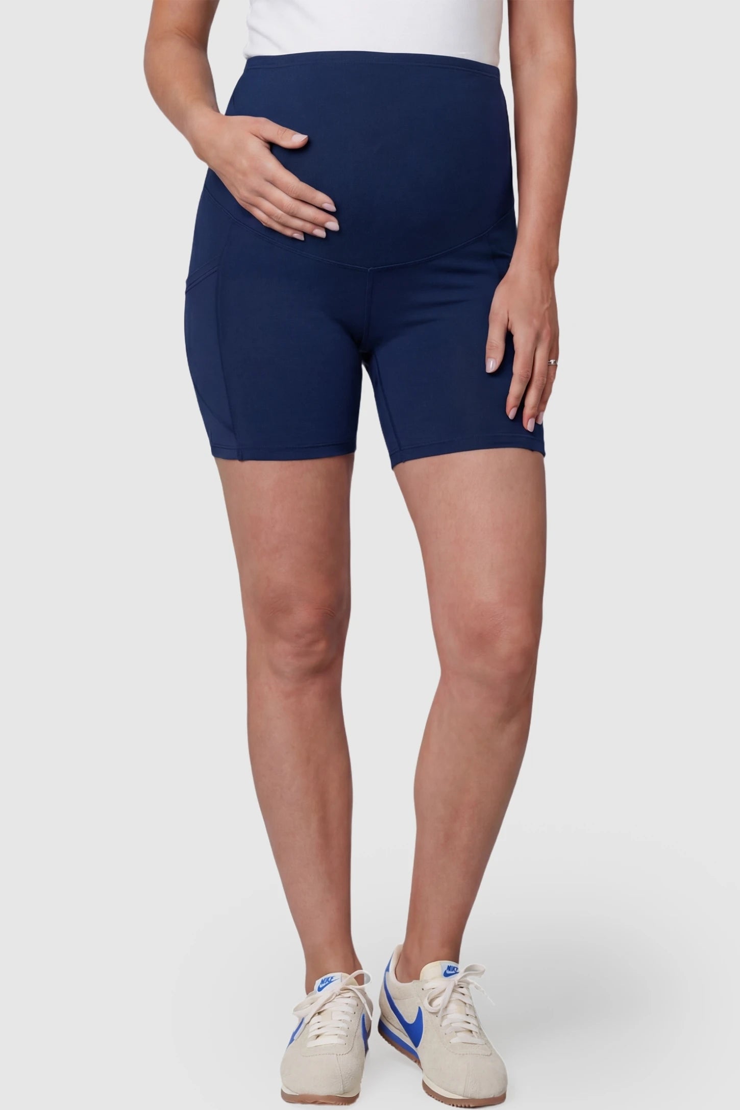 High-Waist Tummy Support Body-Hugging Maternity Shorts High-waist tummy support body-hugging maternity shorts in navy blue with support waistband, front view on pregnant model