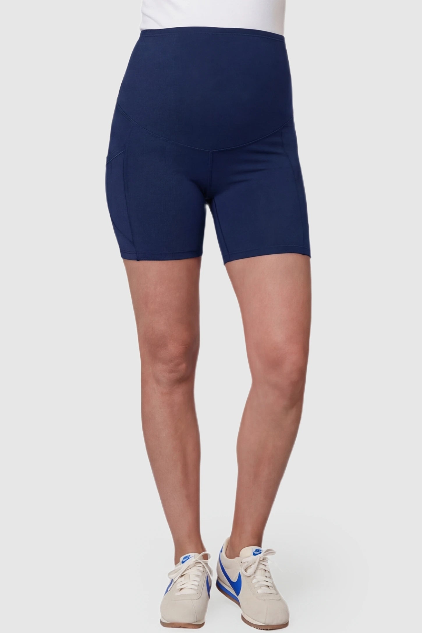 High-Waist Tummy Support Body-Hugging Maternity Shorts High-waist tummy support body-hugging maternity shorts in navy blue with support waistband, front view on pregnant model