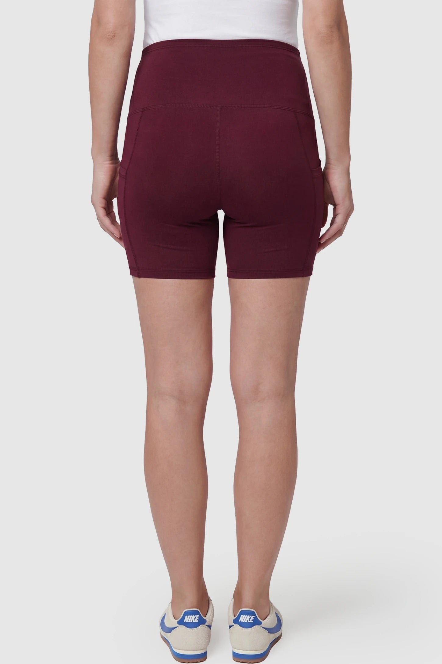 High-Waist Tummy Support Body-Hugging Maternity Shorts High-waist tummy support body-hugging maternity shorts in wine red with smooth rear design, back view on pregnant model