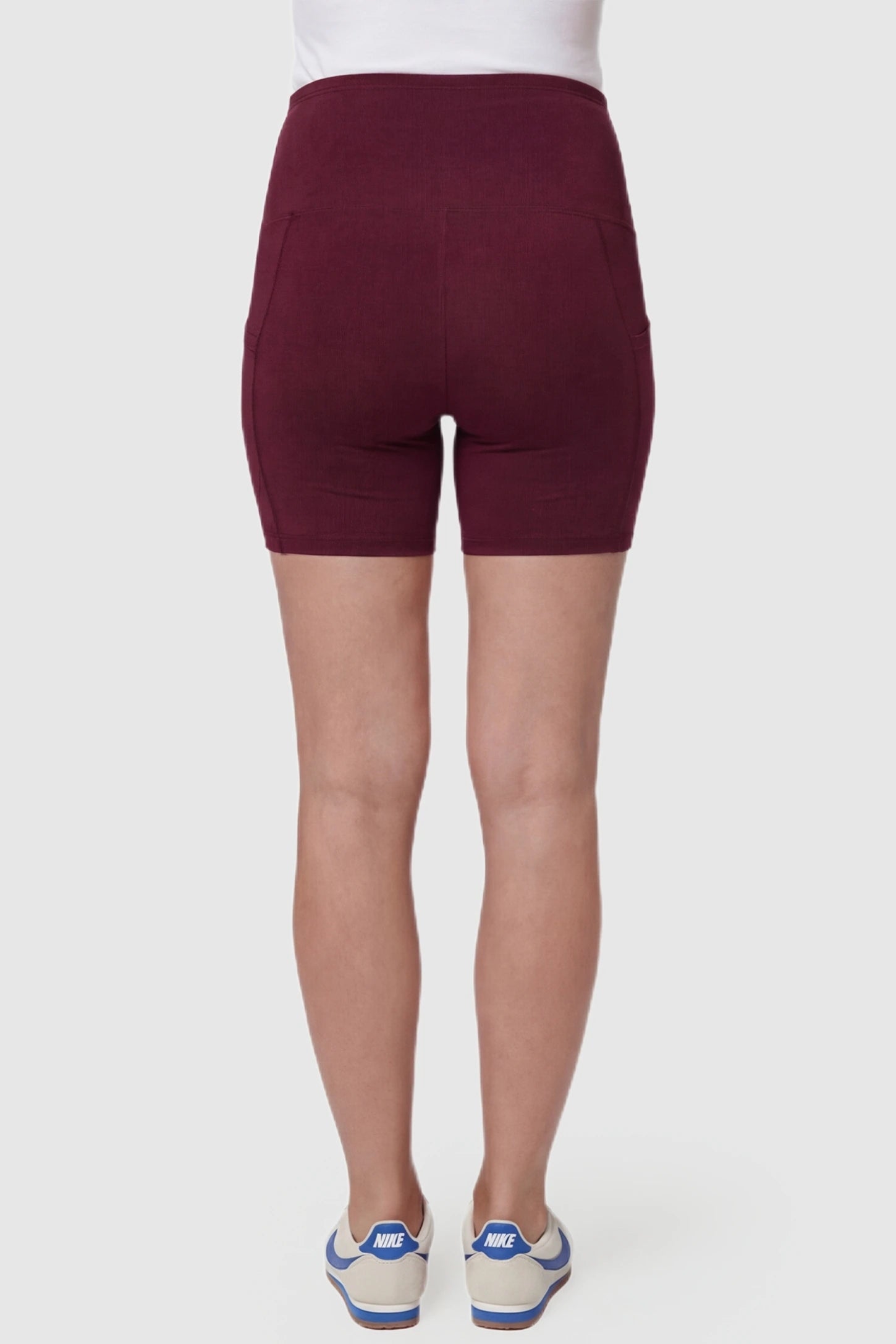 High-Waist Tummy Support Body-Hugging Maternity Shorts High-waist tummy support body-hugging maternity shorts in wine red with smooth rear design, back view on pregnant model