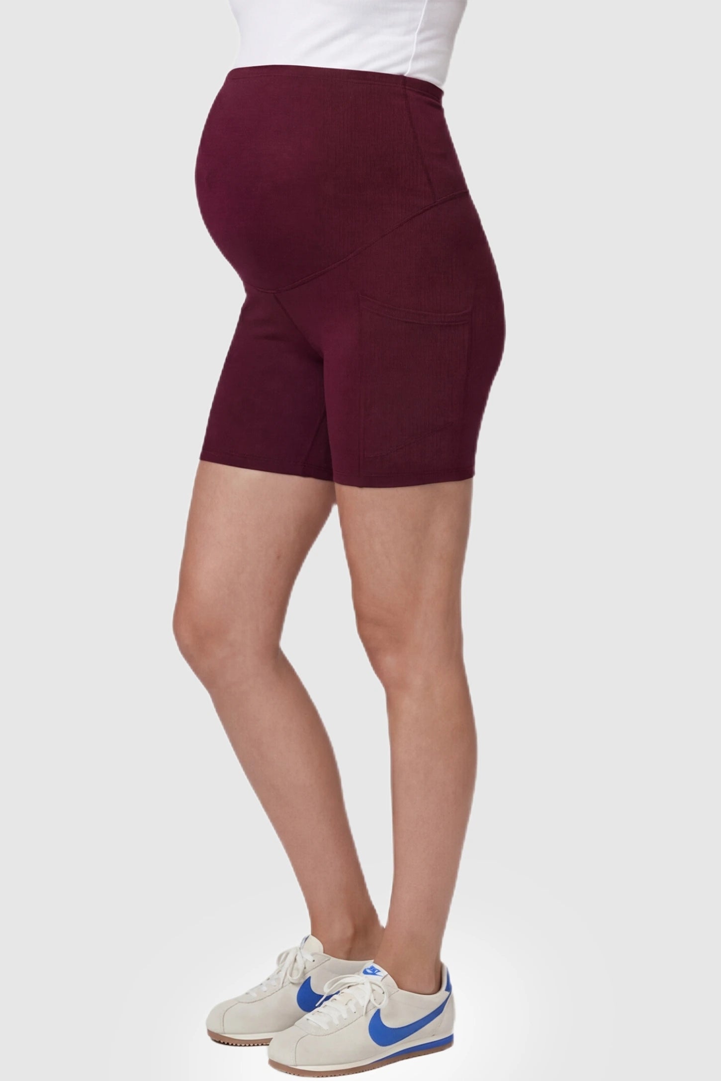 High-Waist Tummy Support Body-Hugging Maternity Shorts High-waist tummy support body-hugging maternity shorts in wine red with flexible stretch, side view on pregnant model