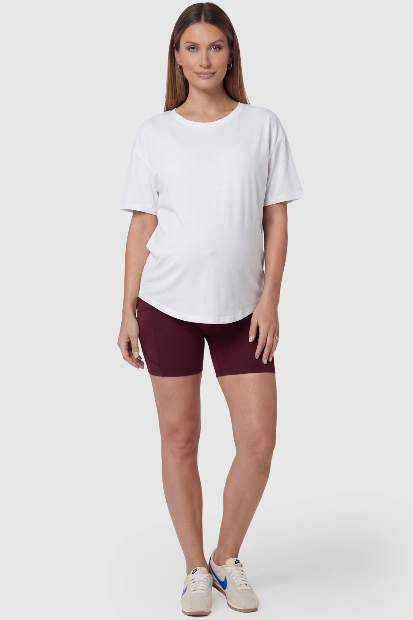 High-Waist Tummy Support Body-Hugging Maternity Shorts High-waist tummy support body-hugging maternity shorts in wine red with sculpted fit, full body on pregnant model