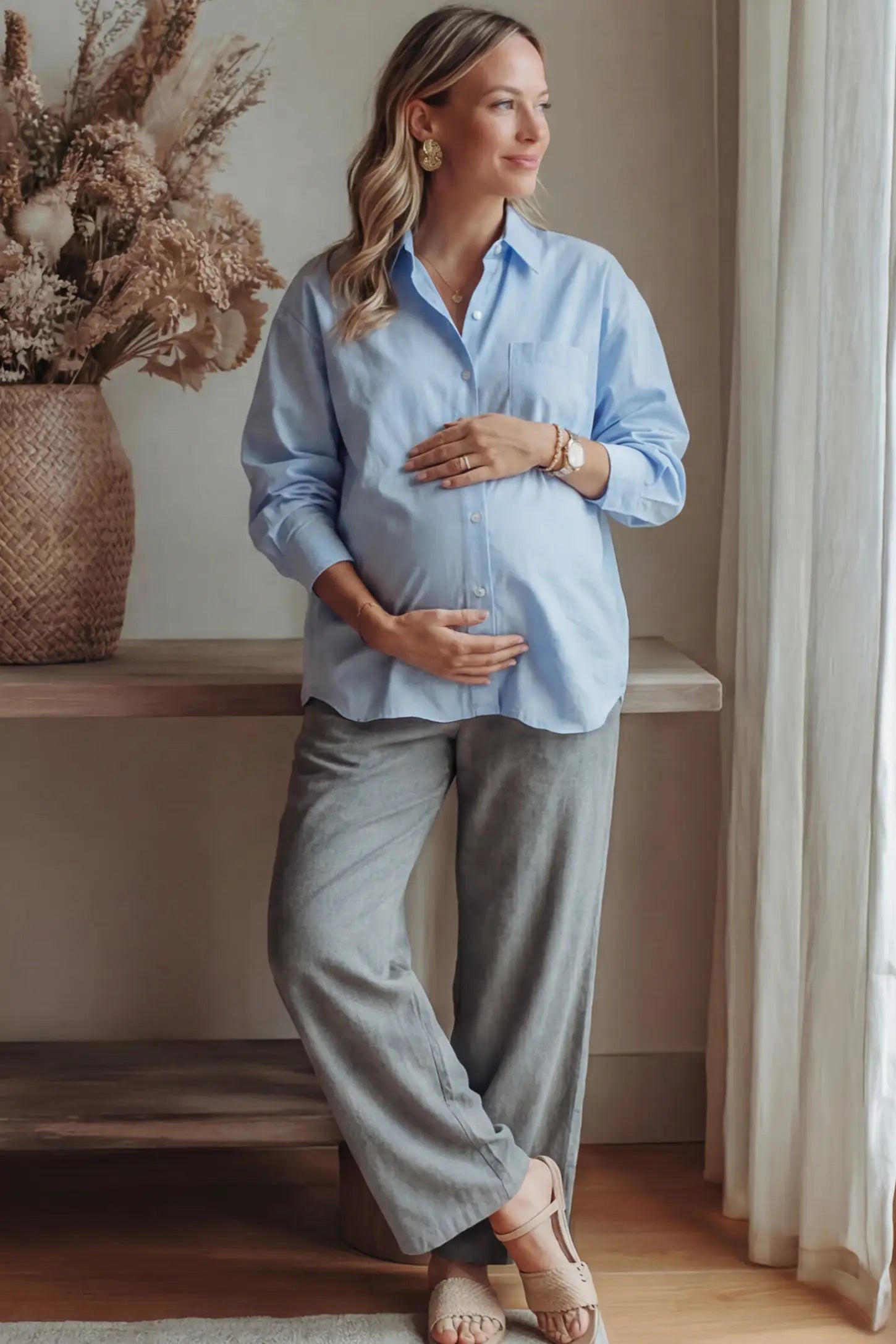 Button Down Collared Maternity Shirt Button Down Collared Maternity Shirt in light blue featuring long sleeves and a crisp cotton finish on a pregnant woman in indoor setting, front view.