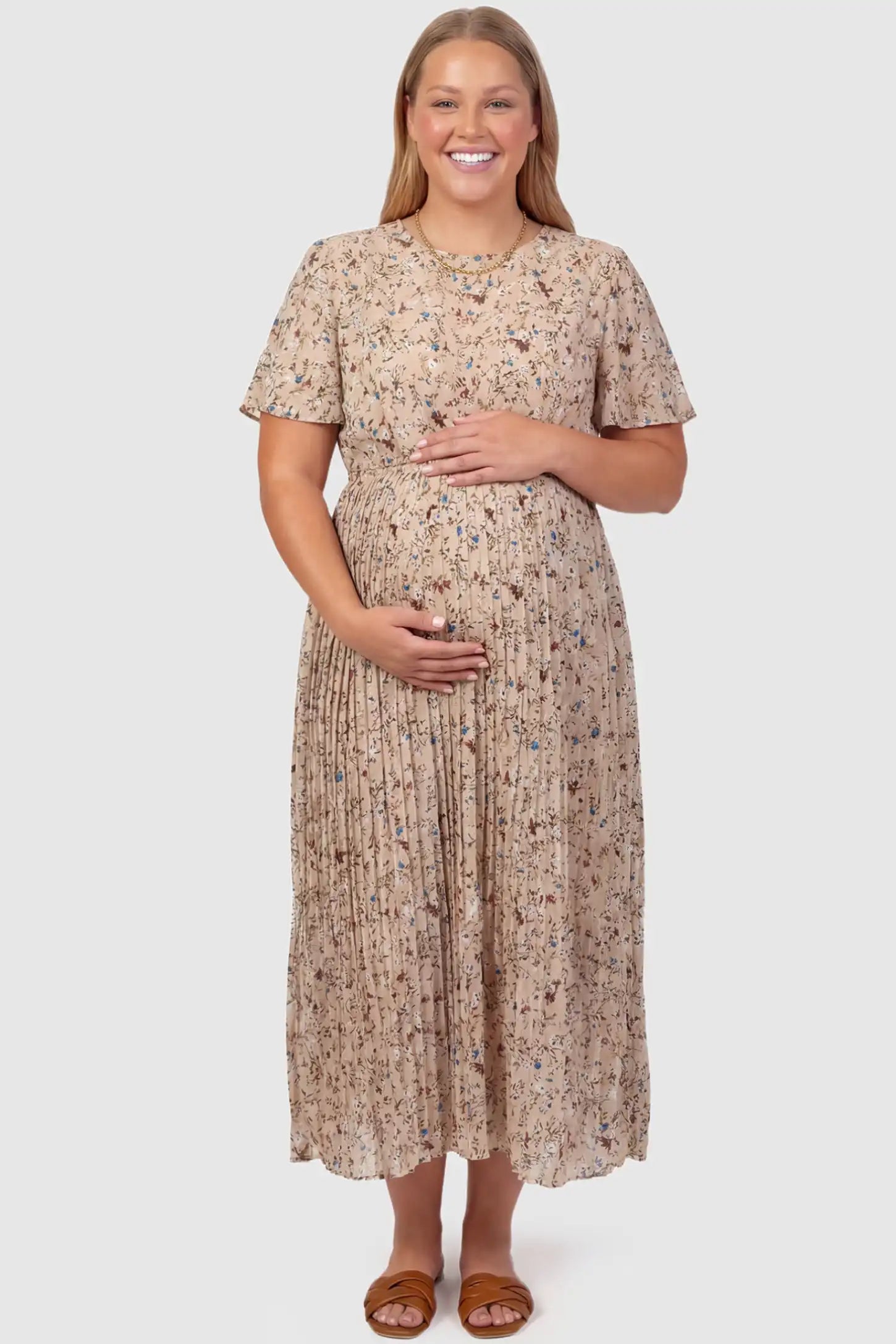 Floral Print Round Neck Pleated Maternity Midi Dress Floral Print Round Neck Pleated Maternity Midi Dress in Beige Floral Print featuring a pleated A-line skirt on a plus size pregnant model, front view.
