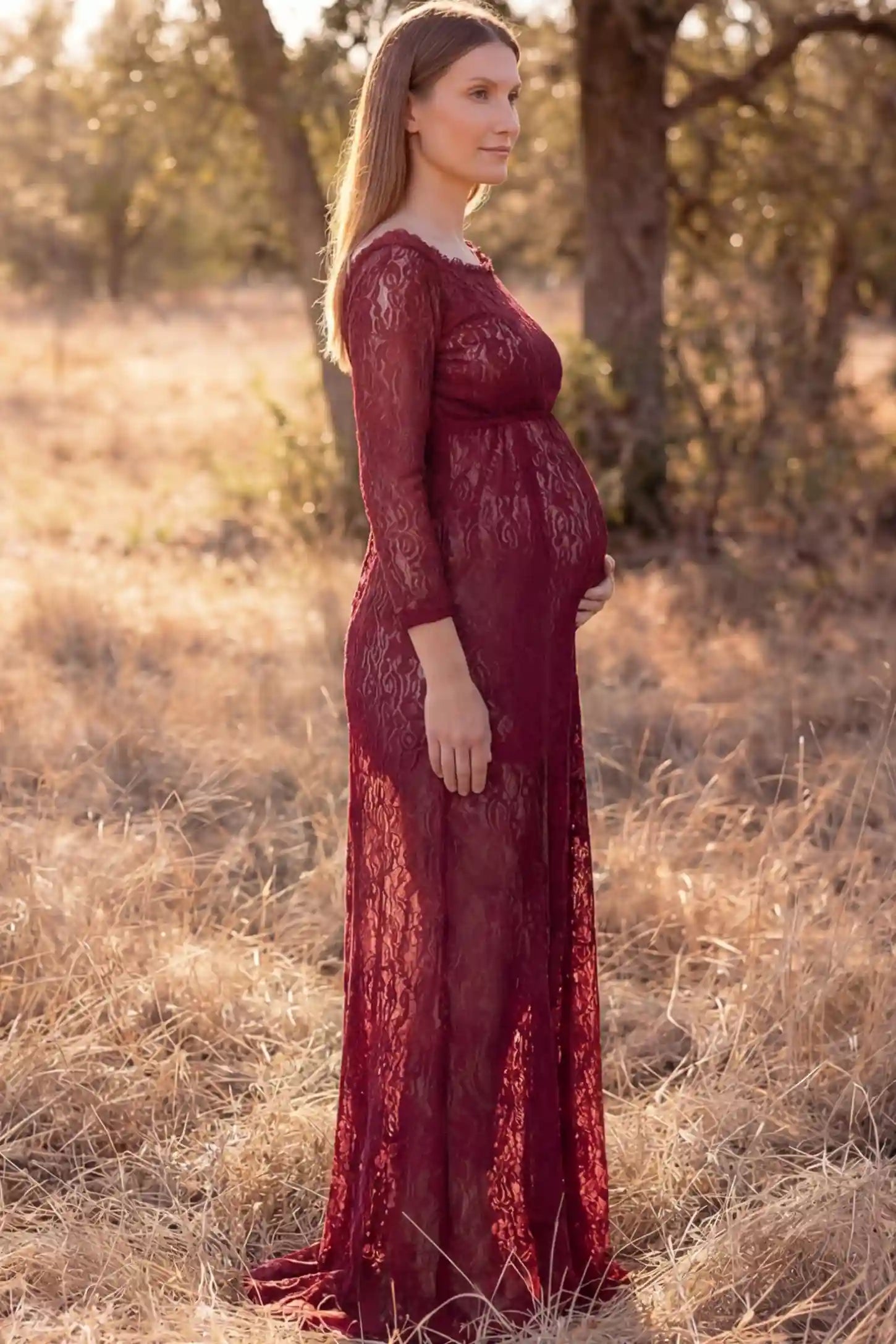Lace Long Sleeve Maternity Photoshoot Dress Lace Long Sleeve Maternity Gown in burgundy featuring scalloped lace trim neckline on pregnant model showing side view.