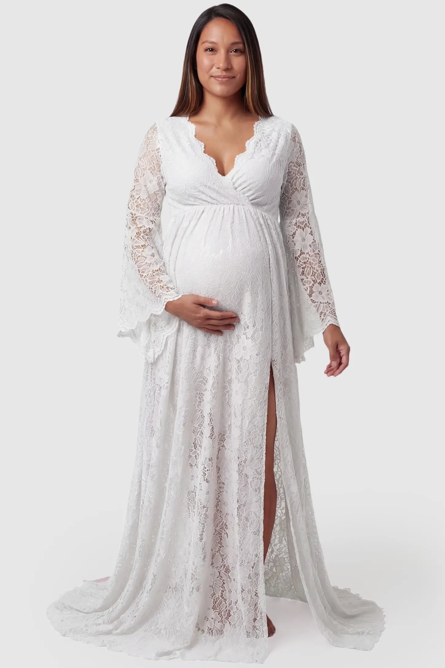 Lace Flare Long Sleeve Maternity Photoshoot Gown in White featuring a delicate floral lace pattern on a pregnant model.