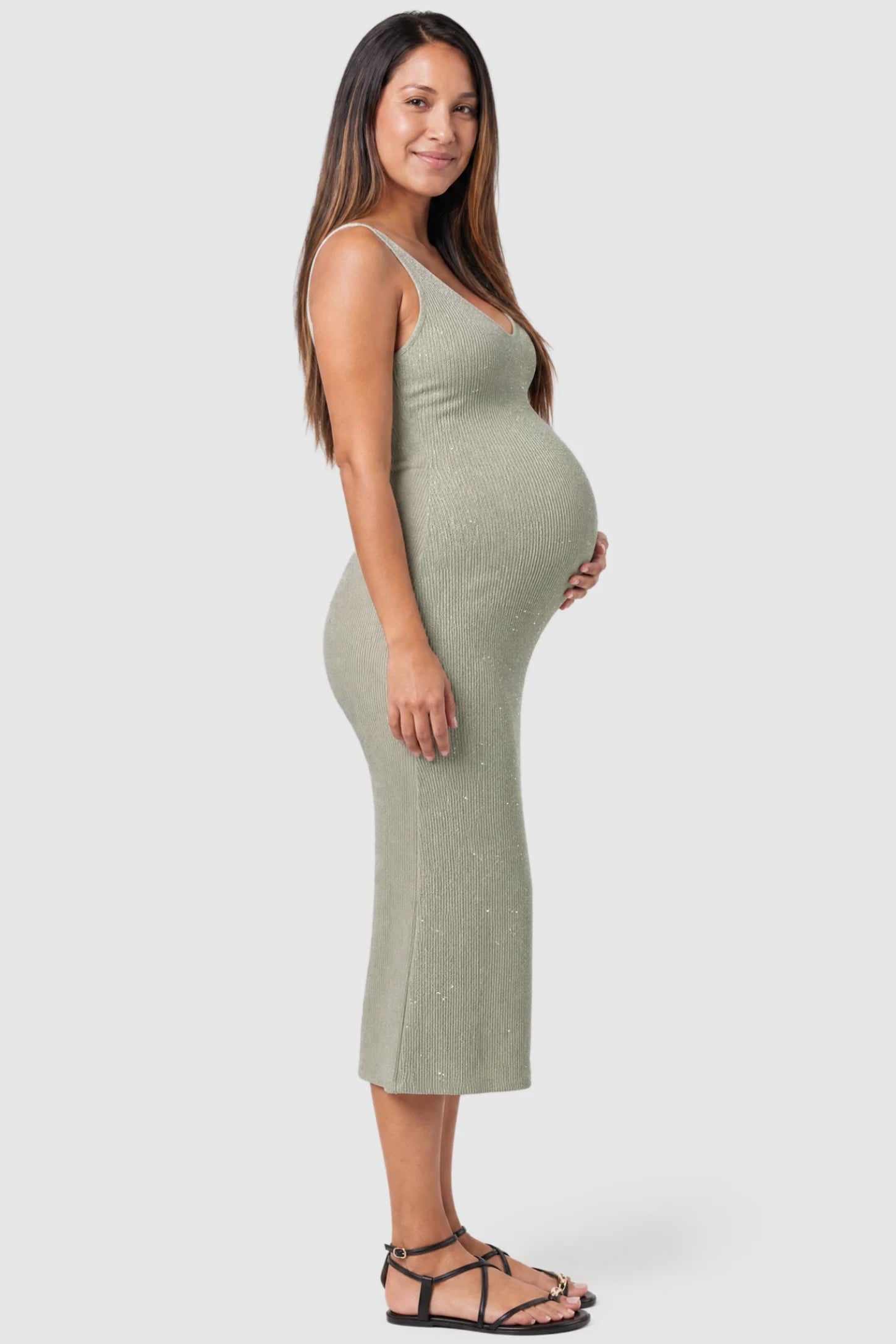 Lurex Shimmer V-Neck Sleeveless Maternity Midi Dress Lurex Shimmer V-Neck Maternity Midi Dress in beige featuring a high-stretch glitter knit on a pregnant model, side view.