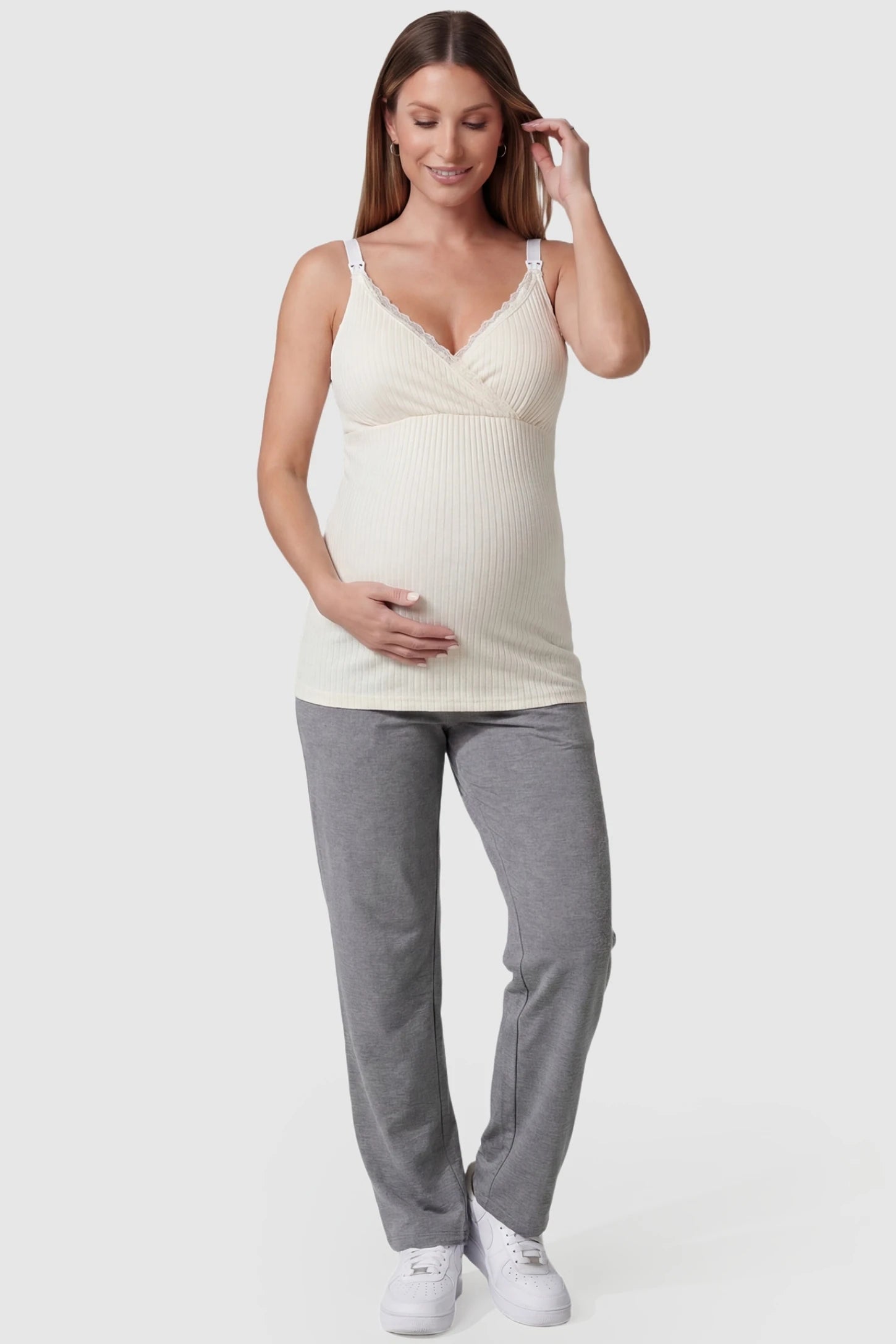 Padded Ribbed Maternity & Nursing Camisole Cream White Padded Ribbed Maternity Camisole with lace-trim V-neckline on a pregnant model in a front view.
