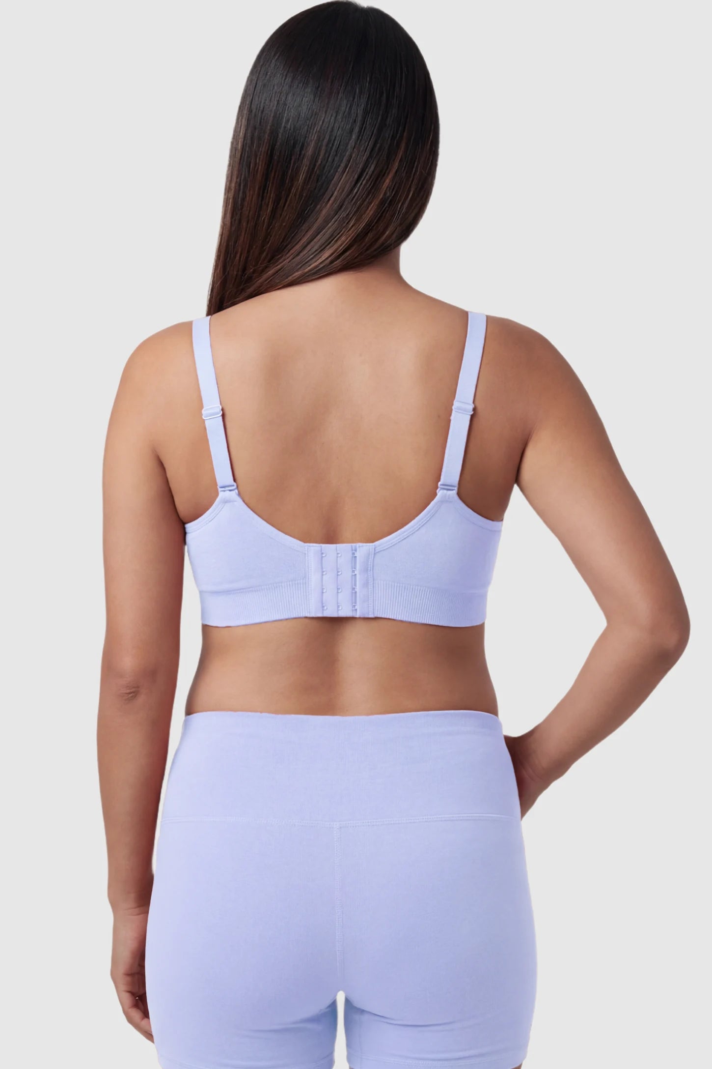 Seamless Ruched Front Maternity Nursing Bra Seamless Ruched Front Maternity Nursing Bra in blue featuring ribbed fabric, adjustable straps, and a multi-hook back closure on a pregnant model from behind.