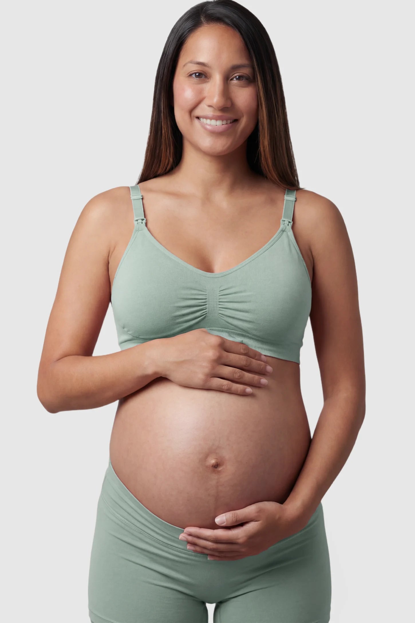 Seamless Ruched Front Maternity Nursing Bra Seamless Ruched Front Maternity Nursing Bra in green featuring ribbed fabric and drop-down clips on a pregnant model showing front.