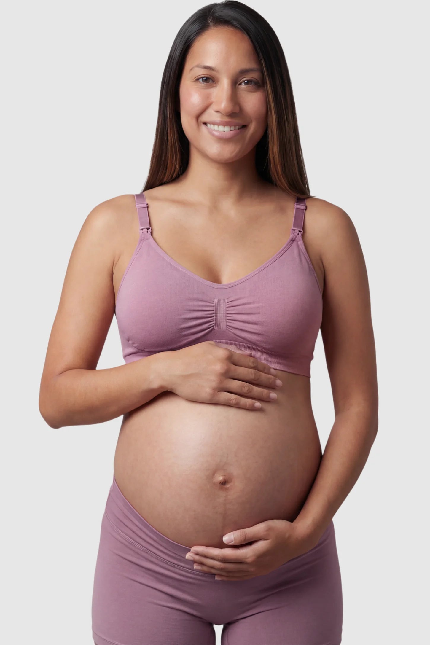 Seamless Ruched Front Maternity Nursing Bra Seamless Ruched Front Maternity Nursing Bra in purple featuring ribbed fabric and drop-down clips on a pregnant model showing front.