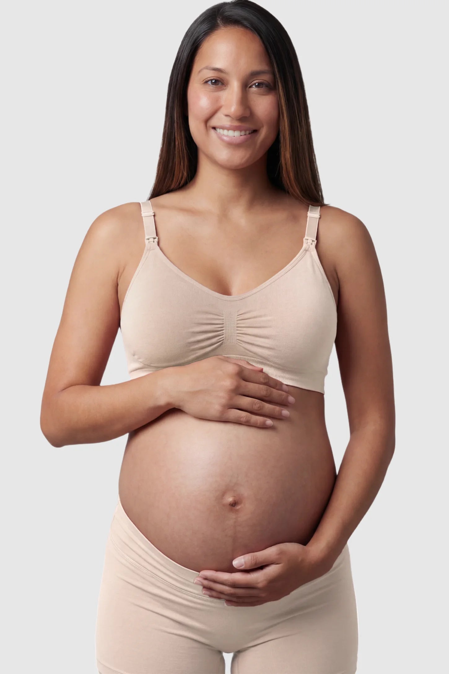 Seamless Ruched Front Maternity Nursing Bra Seamless Ruched Front Maternity Nursing Bra in skin featuring ribbed fabric and drop-down clips on a pregnant model showing front.