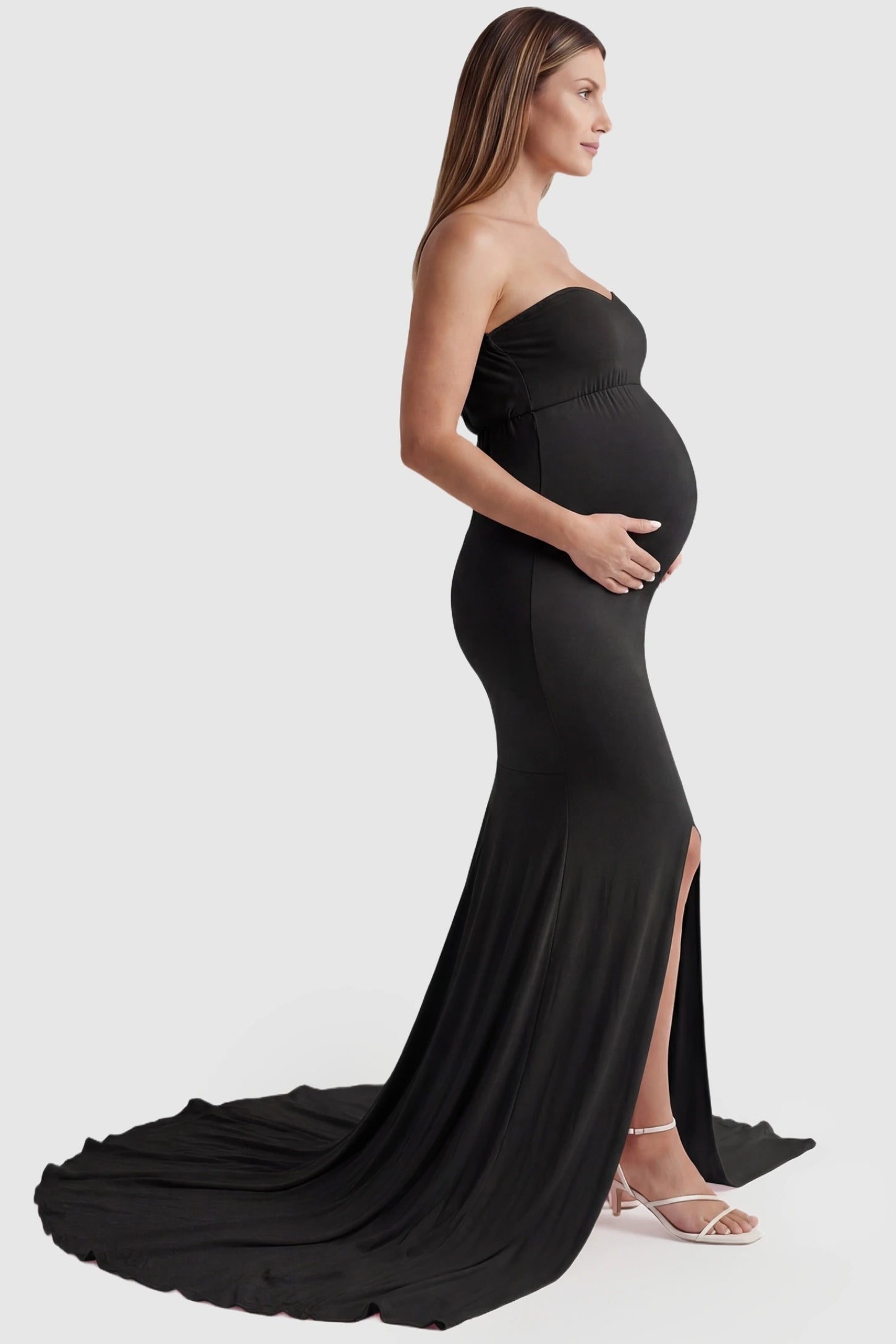 Strapless Sweetheart Neckline Trumpet Silhouette Maternity Gown Strapless Sweetheart Neckline Trumpet Silhouette Maternity Gown in Black featuring a long train on a pregnant model, side view.