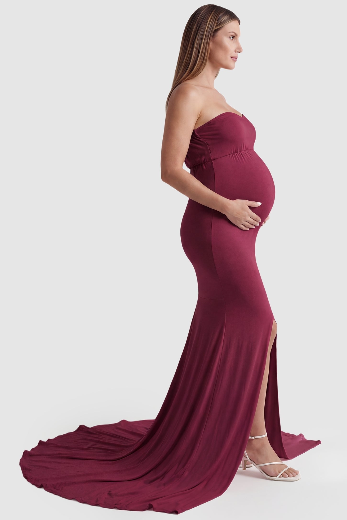 Strapless Sweetheart Neckline Trumpet Silhouette Maternity Gown Strapless Sweetheart Neckline Trumpet Silhouette Maternity Gown in Wine Red featuring a long train on a pregnant model, side view.