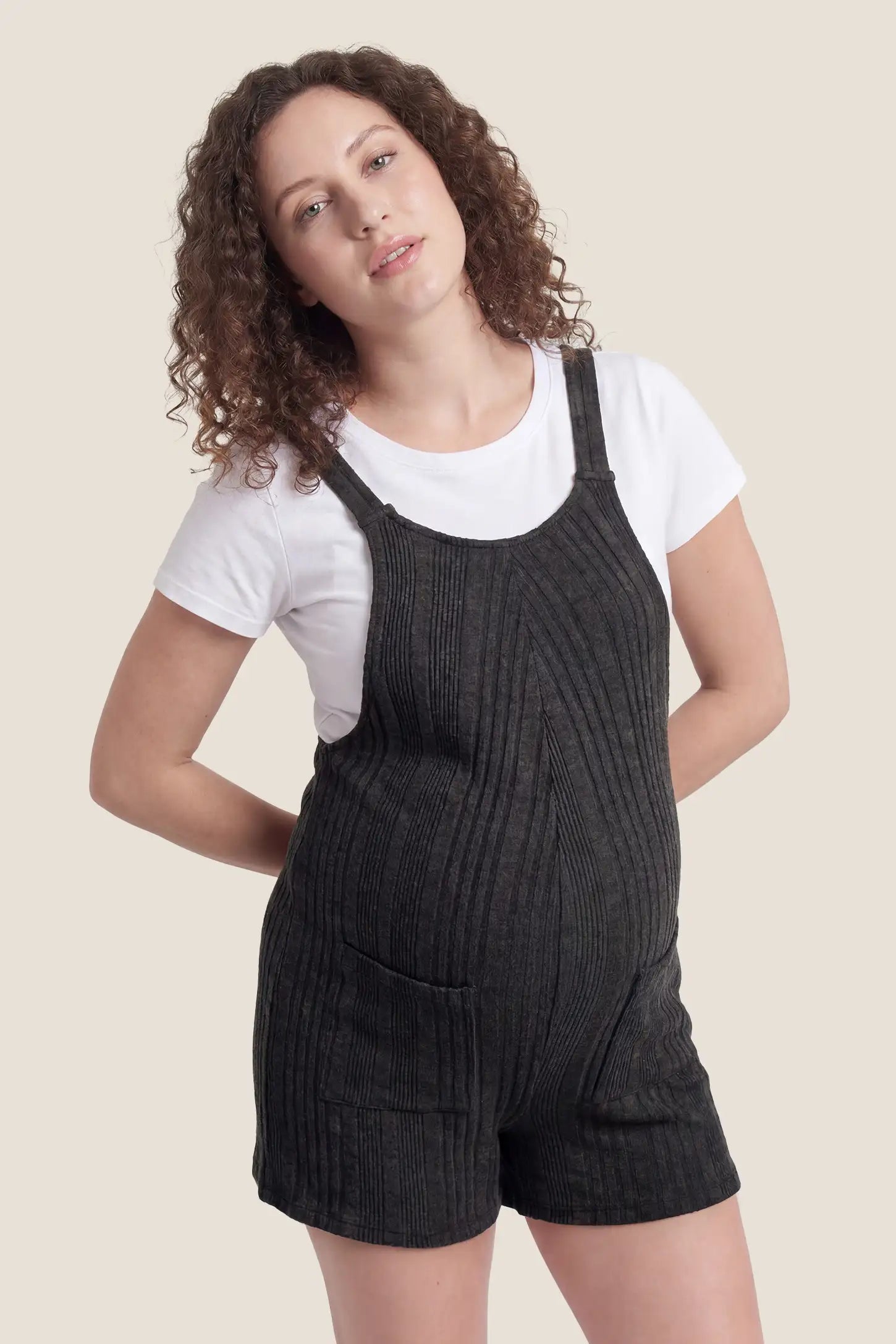 Ribbed Pocket Knit Romper in Black featuring a classic vertical ribbed texture on a pregnant model, front 
view.