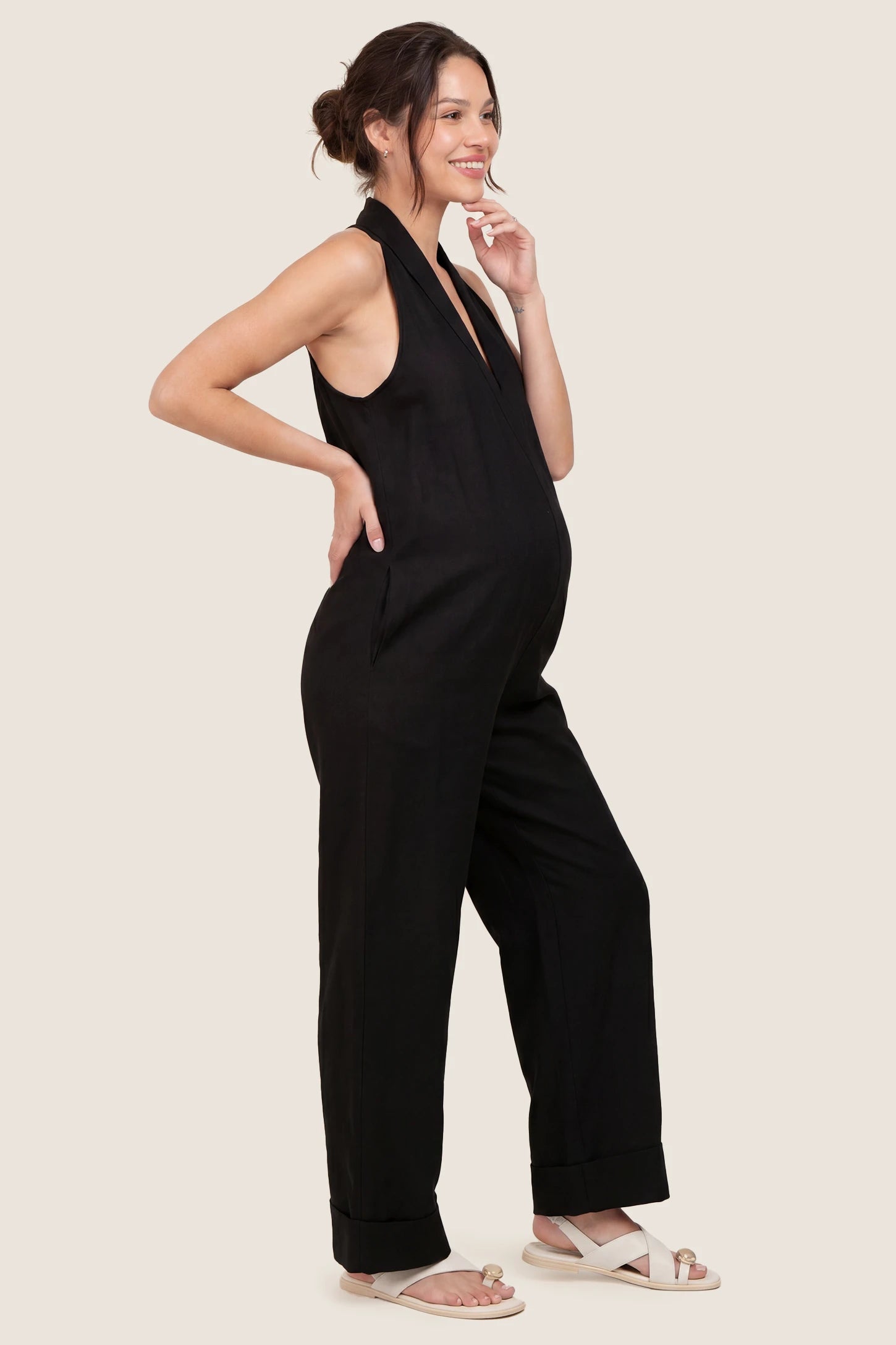 Halter Neck Wide-Leg Maternity Jumpsuit Halter neck wide-leg maternity jumpsuit in black with sleeveless cut, side view on pregnant model
