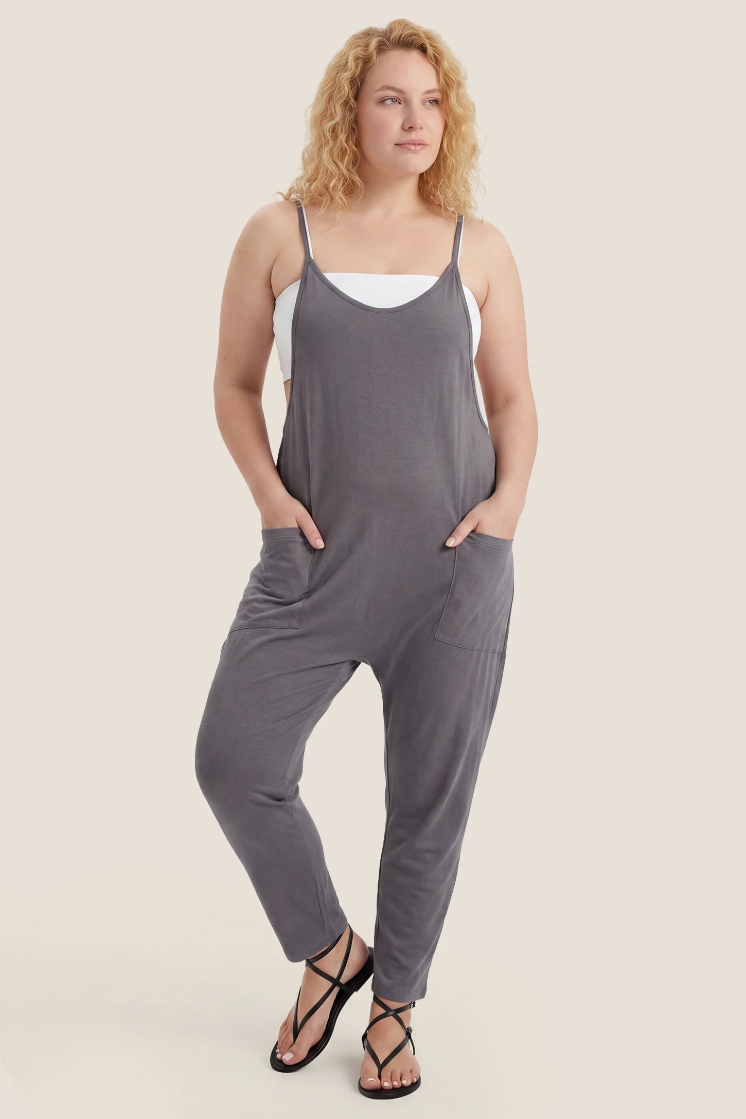 Dark gray adjustable strap pocketed relaxed maternity jumpsuit styled for postpartum wear