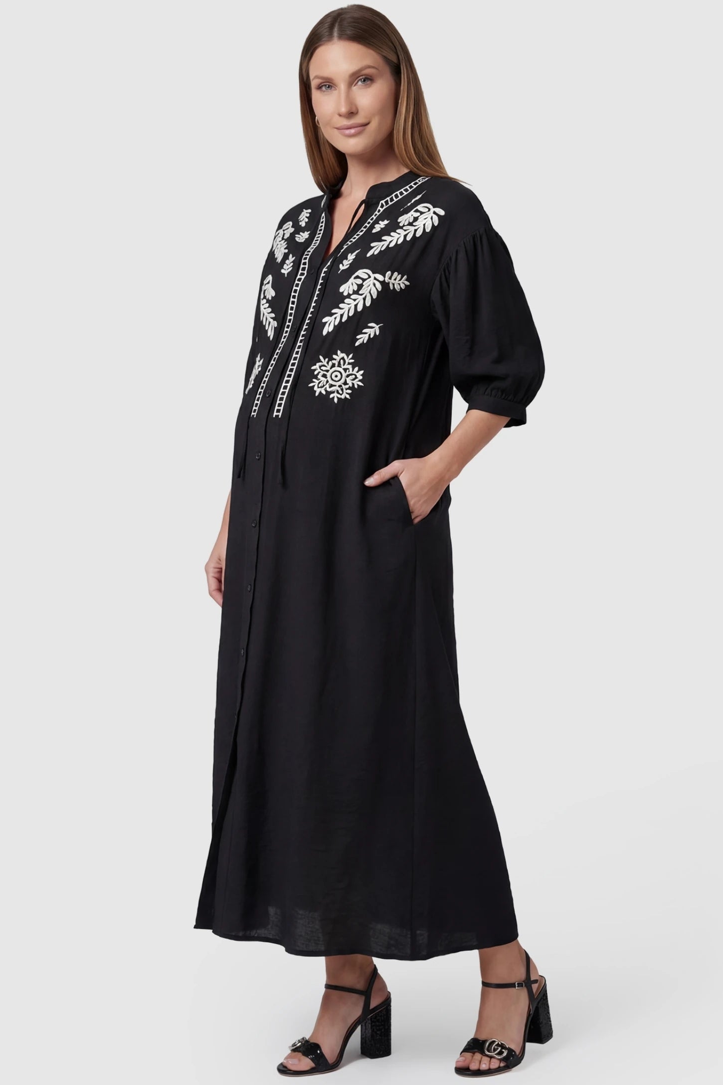 Embroidered Notched Half Sleeve Maternity Midi Dress in Black featuring functional side pockets on a pregnant model.