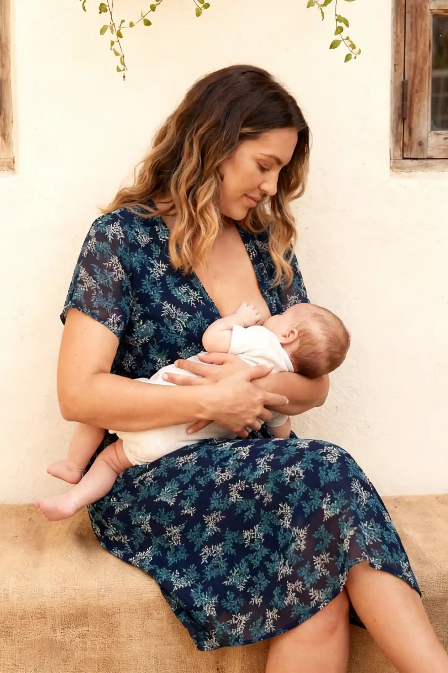 Floral V-Neck Knee-Length Maternity & Nursing Dress Floral V-Neck Knee-Length Maternity & Nursing Dress in Blue featuring the nursing function on a breastfeeding model.