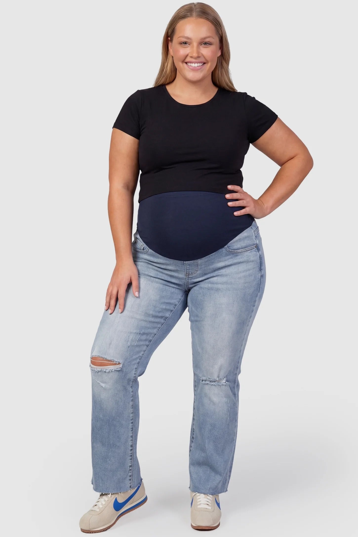 Knee Slit Wide Leg Maternity Jeans Knee Slit Wide Leg Maternity Jeans in Blue denim with distressed knee details front view on a plus size pregnant model.