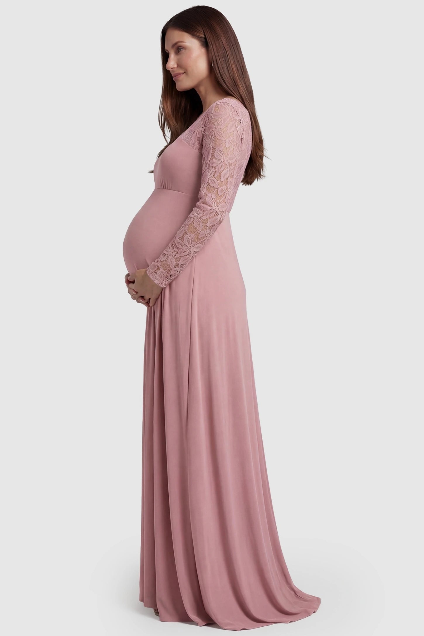 Acrylic Lace Long Sleeve Floor-Length Maternity Dress Acrylic Lace Long Sleeve Floor-Length Maternity Dress in Pink featuring lace-spliced sleeves on a side-profile pregnant model.