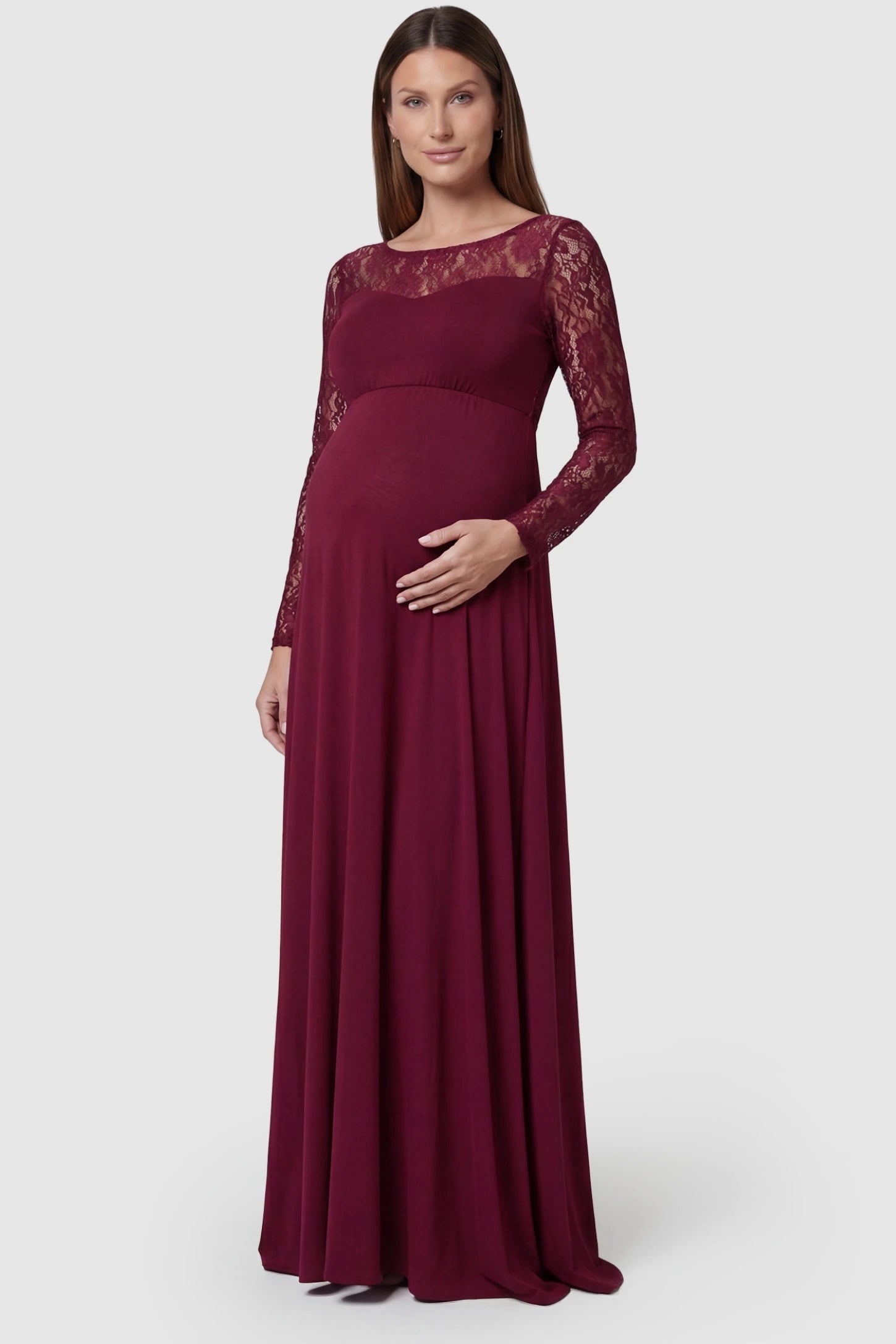 Acrylic Lace Long Sleeve Floor-Length Maternity Dress Acrylic Lace Long Sleeve Floor-Length Maternity Dress in Wine Red featuring a round neck on a front-facing pregnant model.