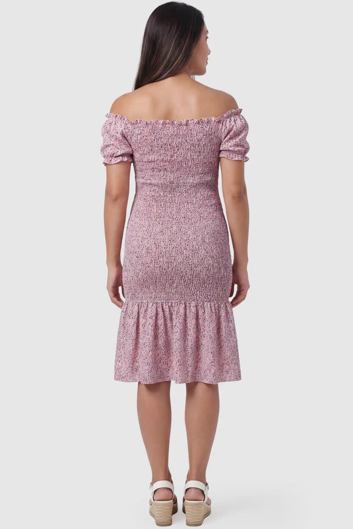 Floral Off Shoulder Smocked Maternity Fishtail Dress Floral Off Shoulder Smocked Maternity Fishtail Dress in Pink Floral featuring an elastic smocked bodice on the back of a pregnant model.