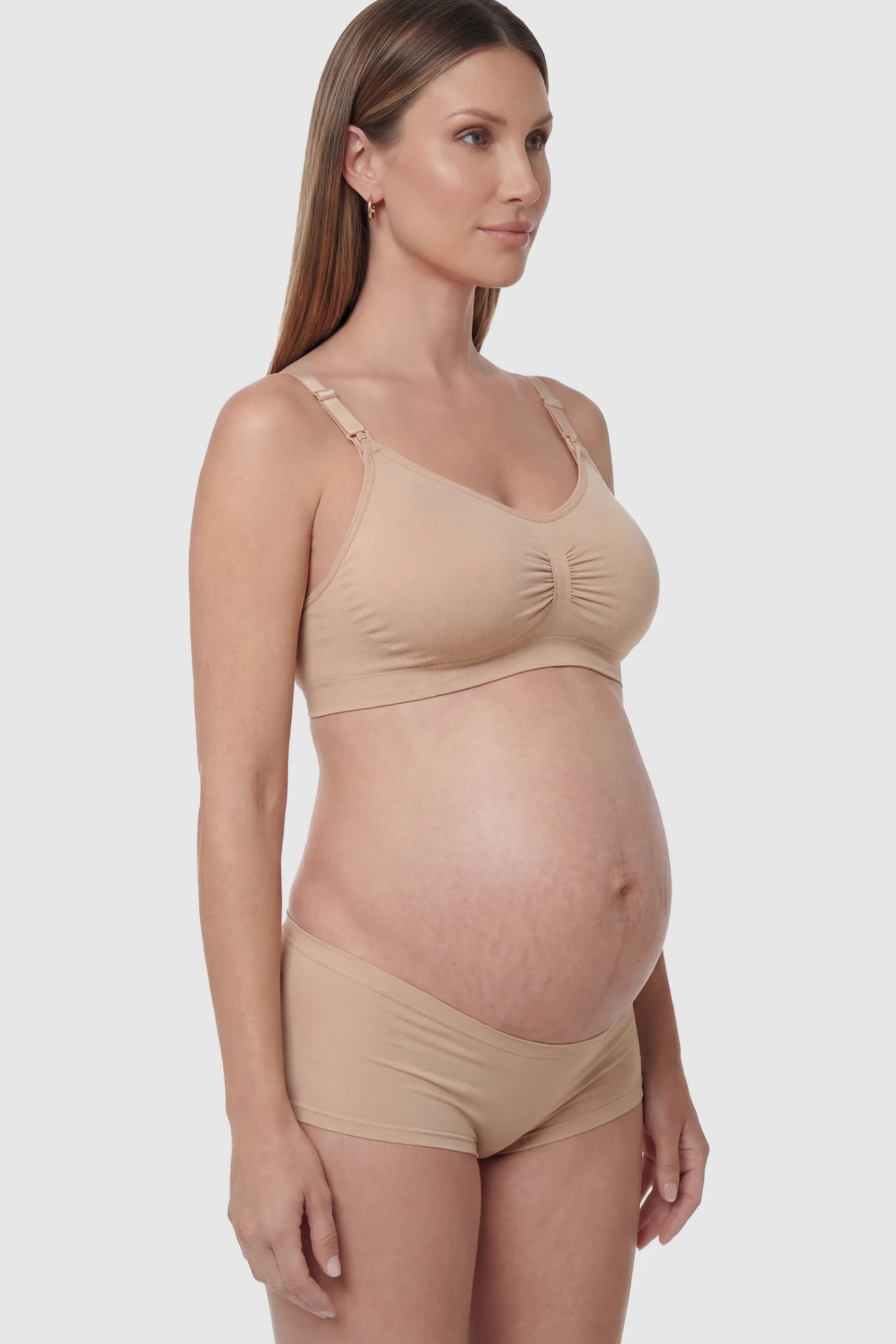 Seamless Ruched Front Wireless Maternity Nursing Bra Seamless Ruched Wireless Nursing Bra in Lotus Root Pink with one-handed clips and adaptive stretch on a pregnant model.