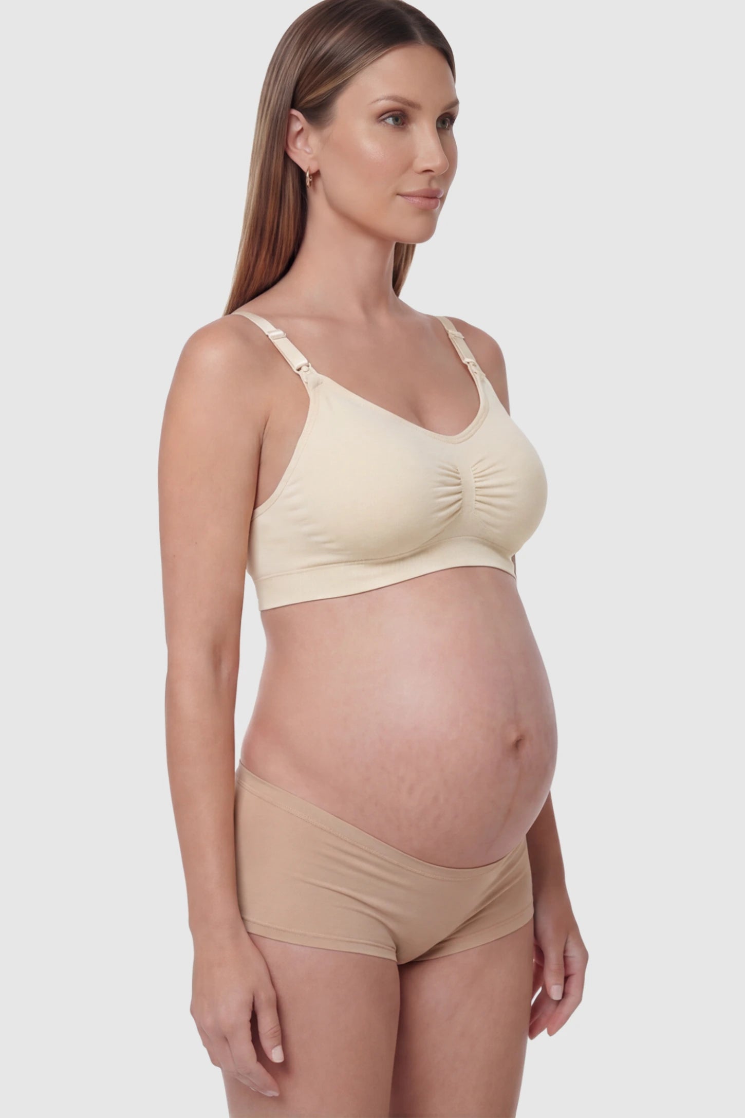 Seamless Ruched Front Wireless Maternity Nursing Bra Seamless Ruched Wireless Nursing Bra in Skin with one-handed clips and adaptive stretch on a pregnant model.