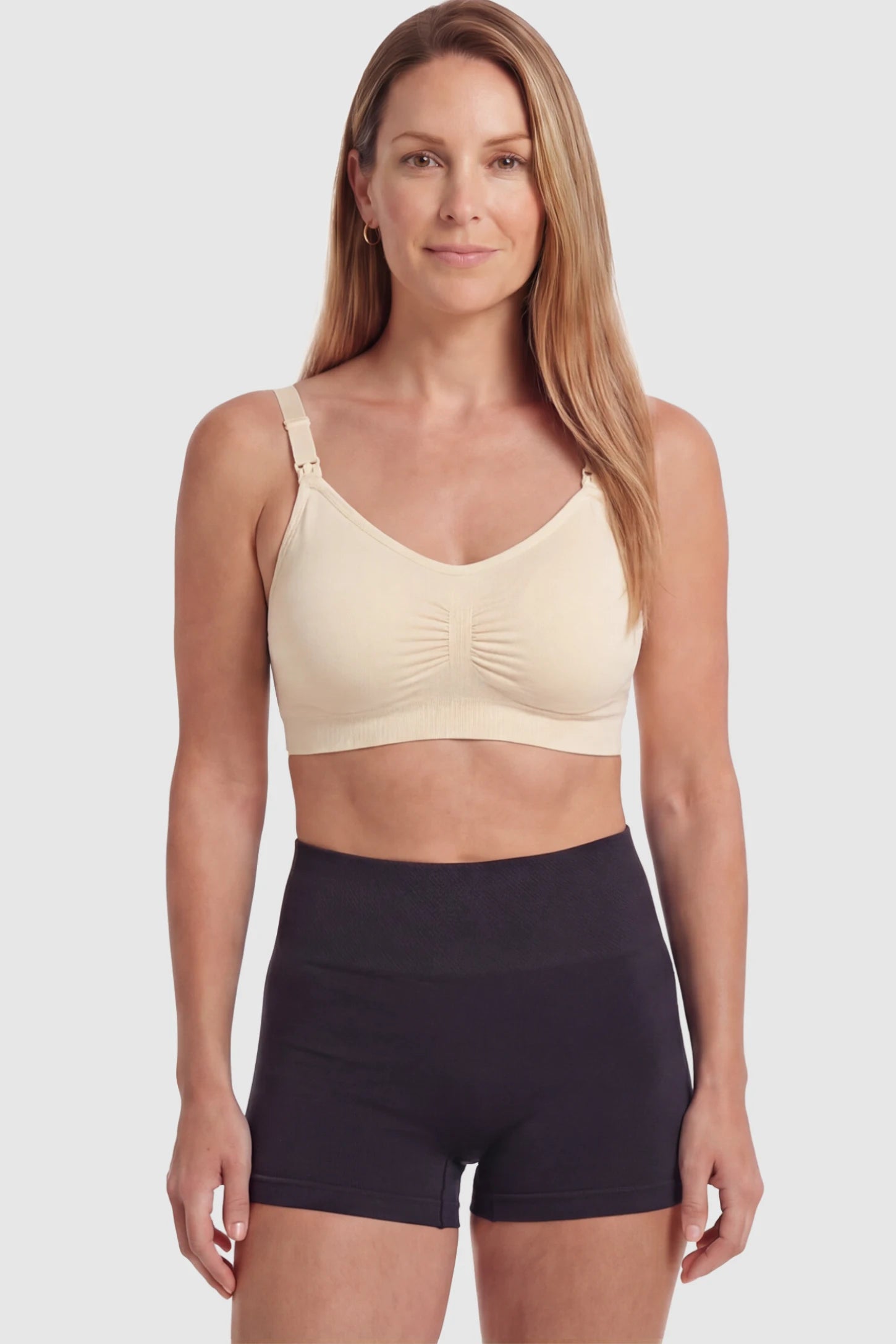 Seamless Ruched Front Wireless Maternity Nursing Bra Seamless Ruched Wireless Nursing Bra in Skin with one-handed clips and adaptive stretch on a postpartum model.