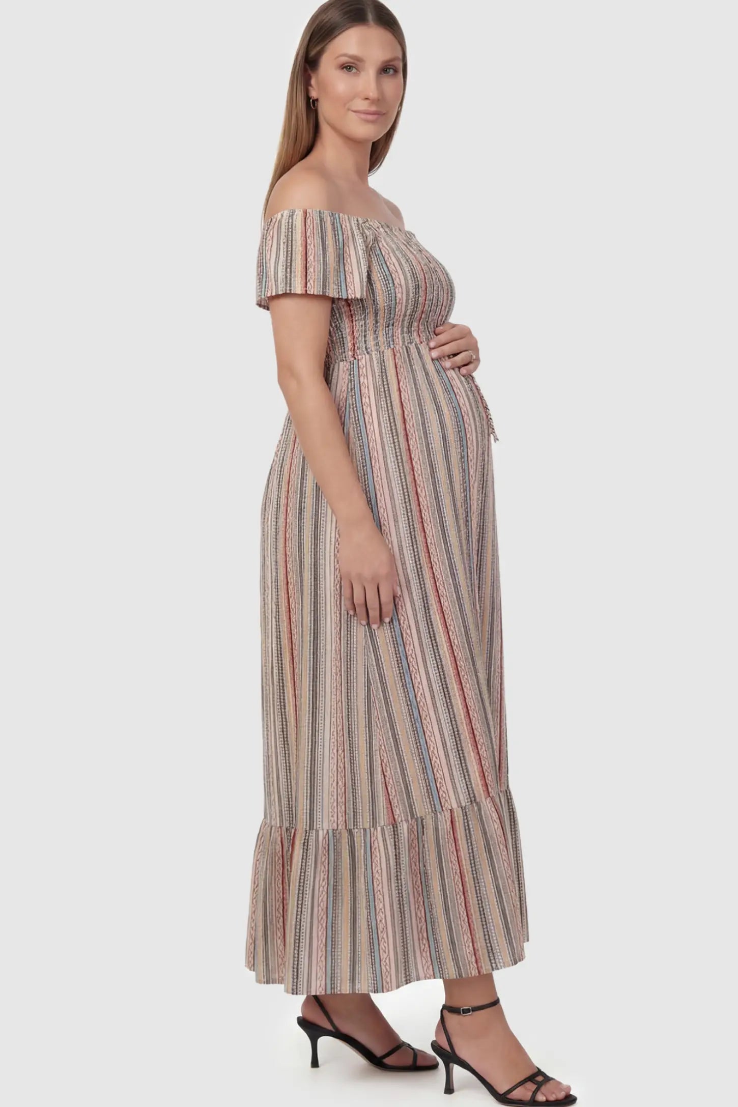 Striped Off-the-Shoulder Ruffle Hem Maternity Maxi Dress in multi colors featuring a flounced hem on a pregnant model.