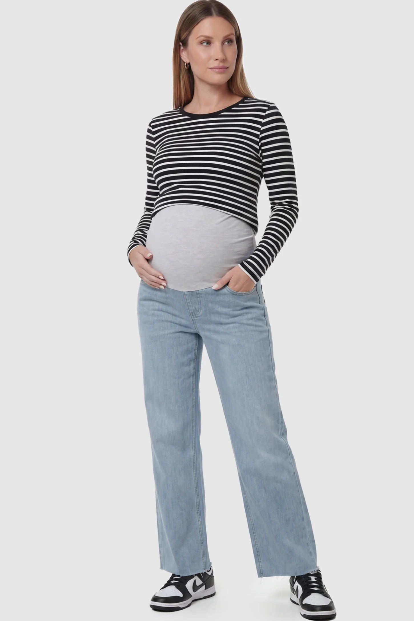 Full Panel Wide Leg Maternity Jeans Full Panel Wide Leg Maternity Jeans in Light Blue featuring a seamless tummy-support band on a pregnant model facing front.