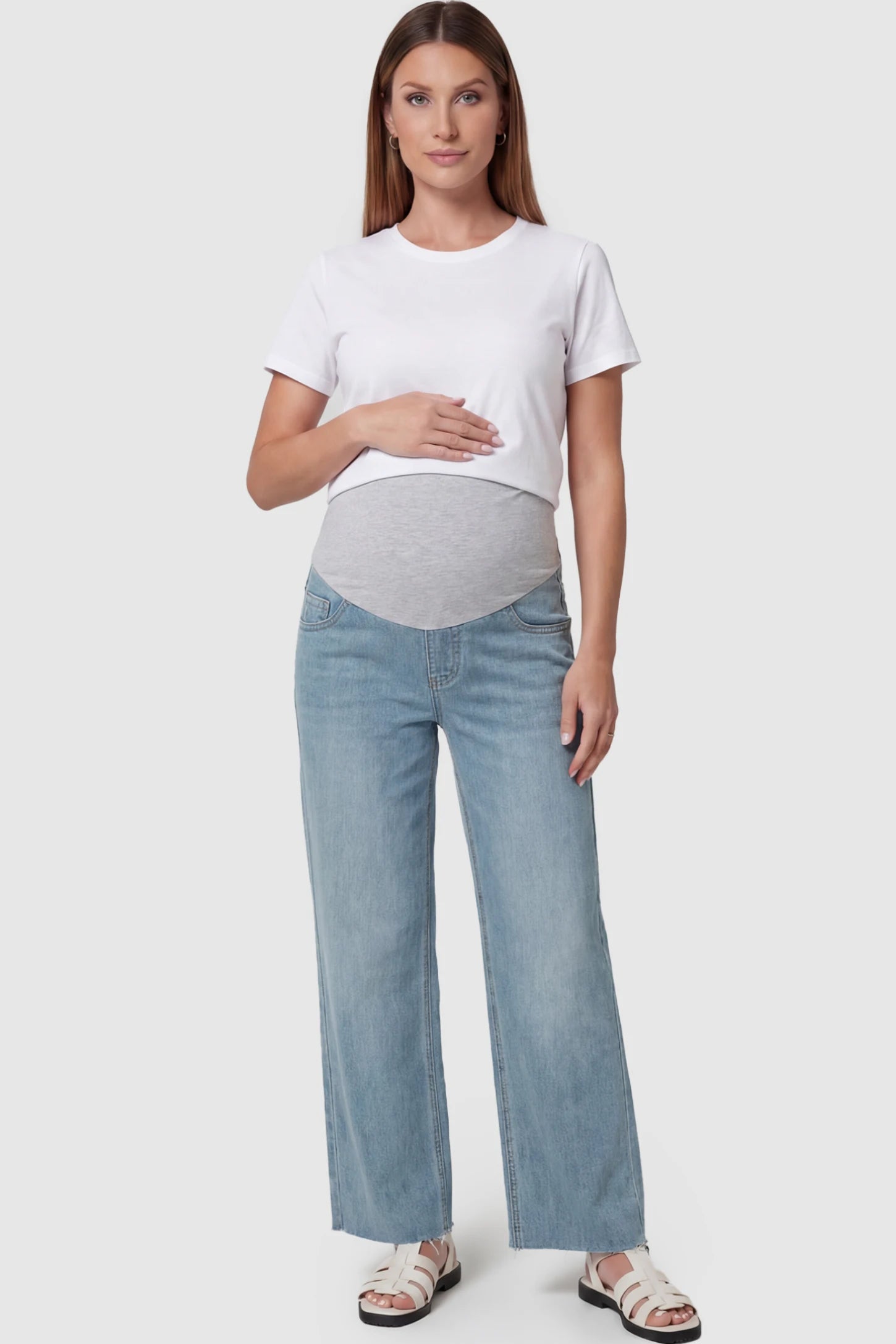 Full Panel Wide Leg Maternity Jeans Full Panel Wide Leg Maternity Jeans in Light Blue featuring a seamless tummy-support band on a pregnant model facing front.