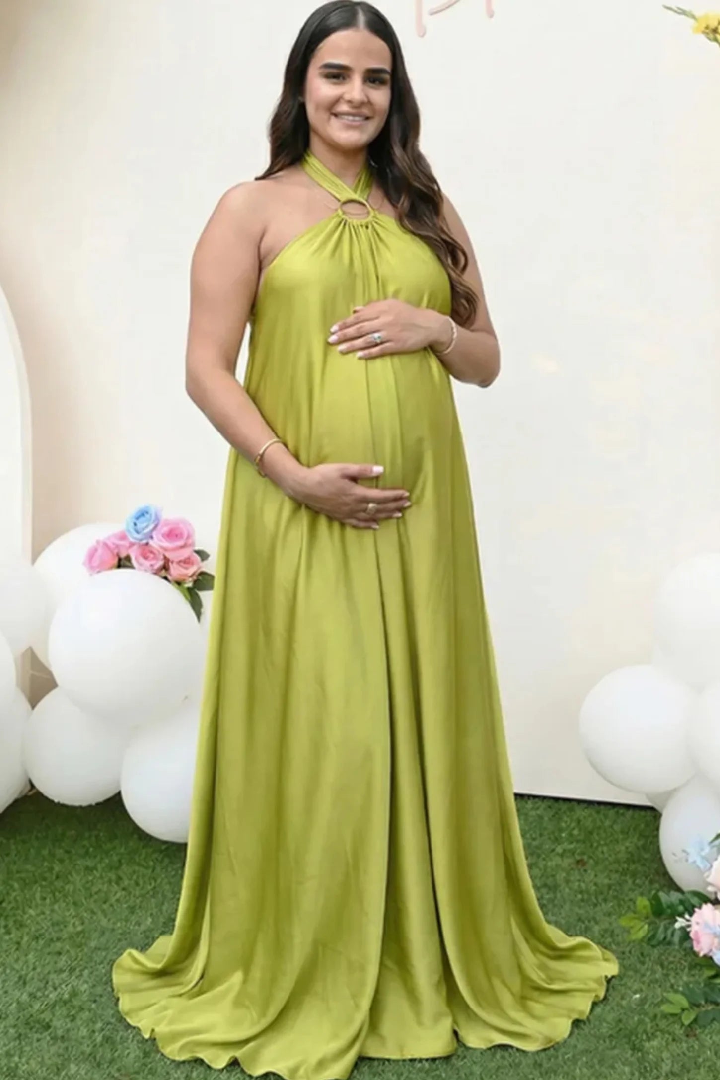 Solid Halter Neck Maternity Maxi Dress Solid Halter Neck Maternity Maxi Dress in Green featuring a flowing skirt on a pregnant model.