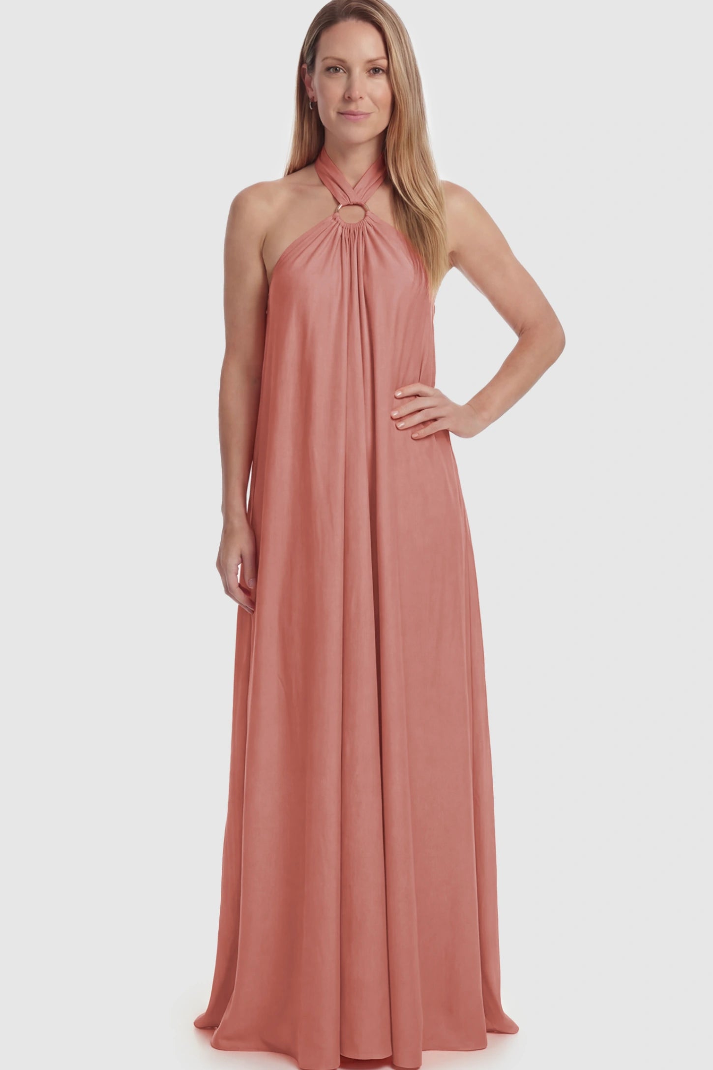 Solid Halter Neck Maternity Maxi Dress Solid Halter Neck Maternity Maxi Dress in Pink featuring a flowing skirt on a postpartum model.