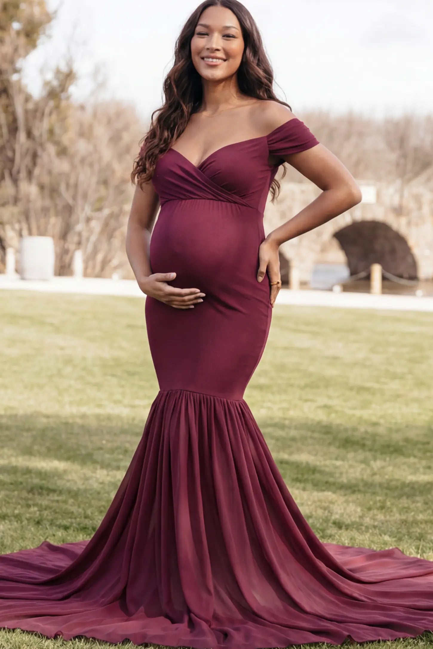 Solid Off Shoulder Mermaid Maternity Photoshoot Gown Off Shoulder Mermaid Maternity Photoshoot Gown in Burgundy featuring a dramatic chiffon train on a pregnant model.