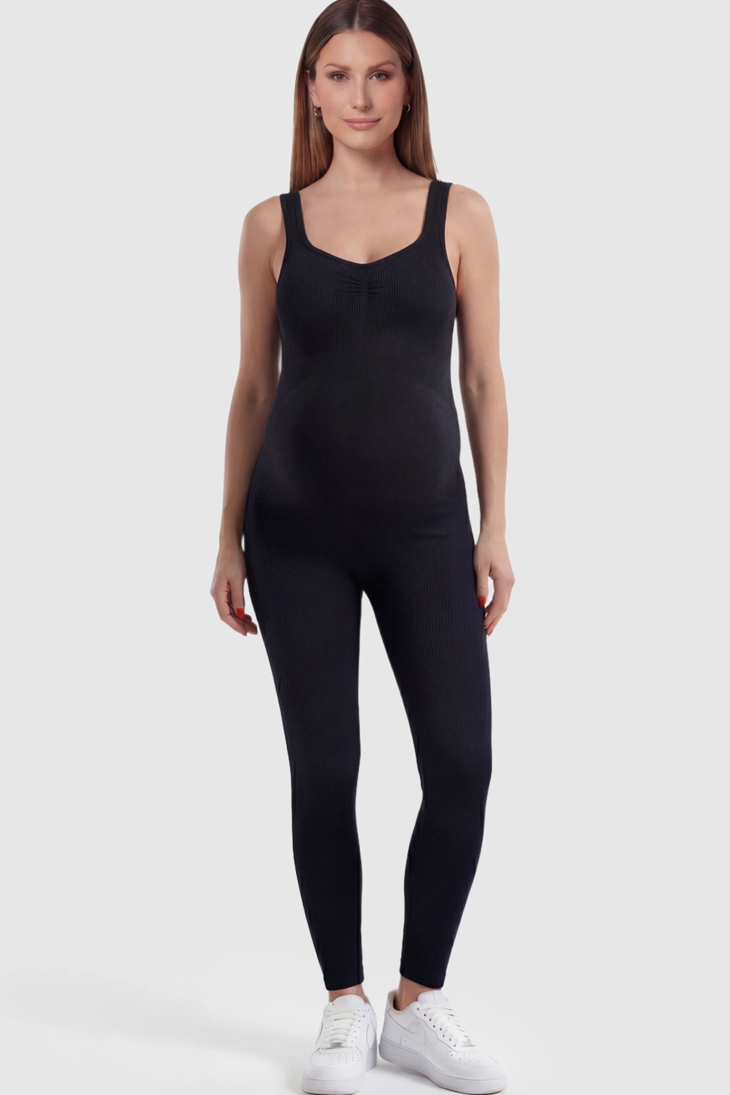 Scoop Neck Sleeveless Ribbed Bodycon Maternity Jumpsuit in Black featuring a seamless texture on a pregnant model.