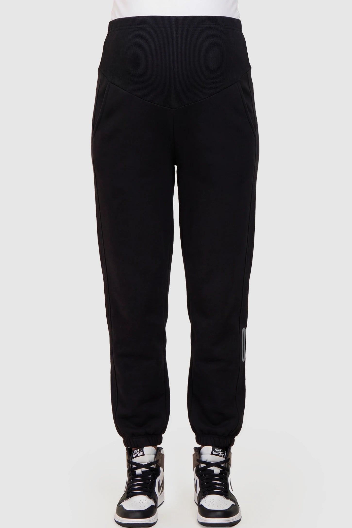 Cotton Blend Full Panel Tapered Leg Maternity Joggers in Black featuring a high-waisted support band on a pregnant model showing front.