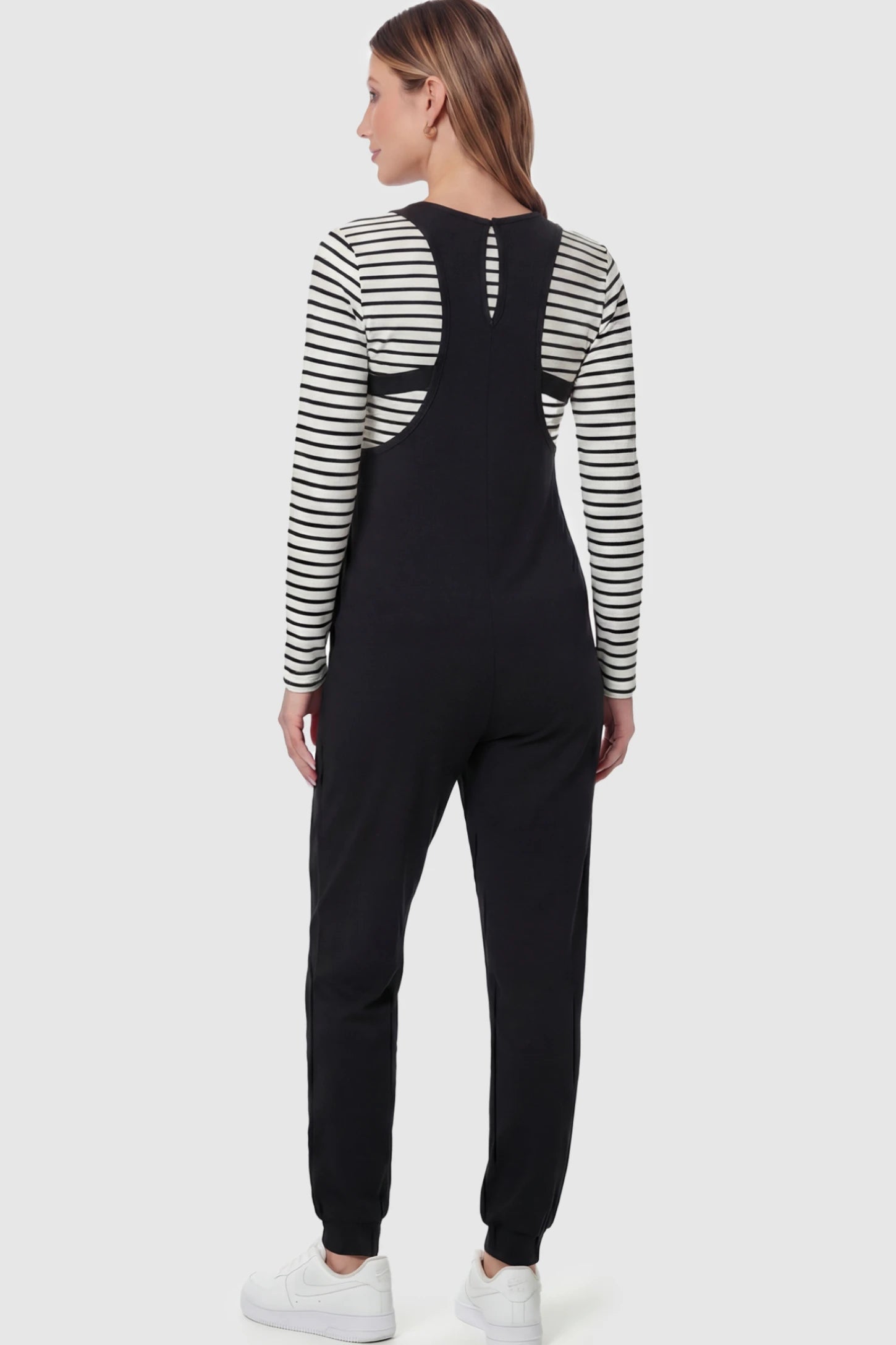 V-Neck Pocketed Maternity Jogger Jumpsuit V-Neck Pocketed Maternity Jogger Jumpsuit in Black featuring cotton-spandex jersey on a model.