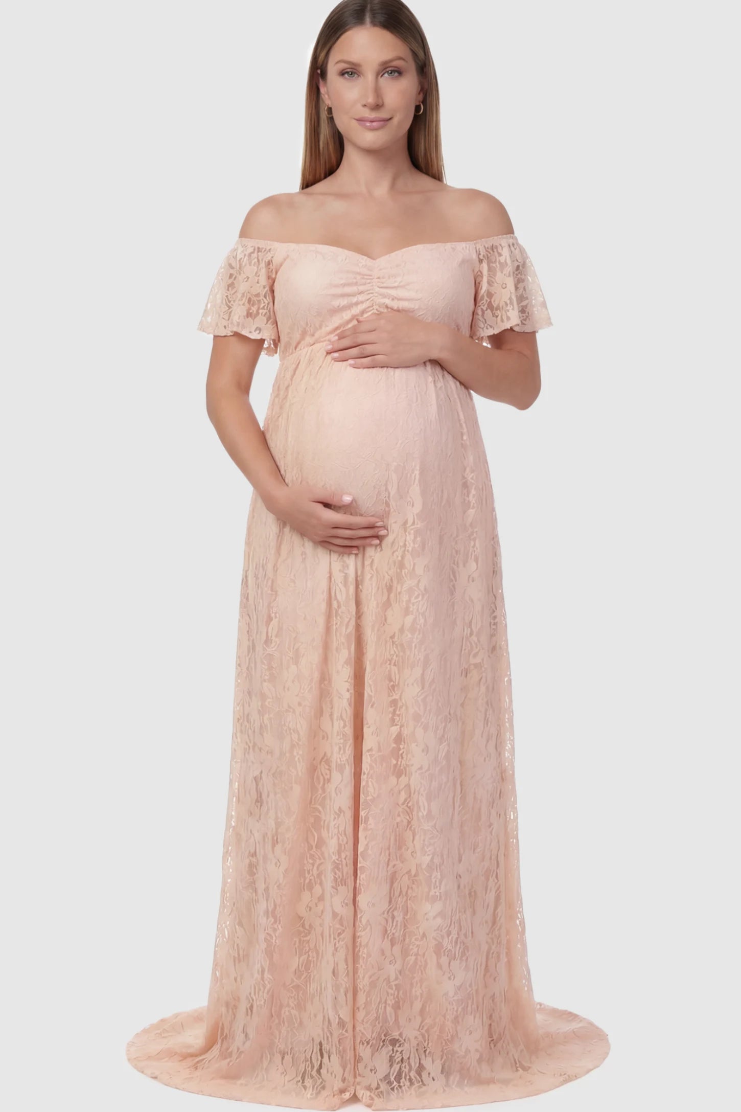 Floral Lace Off The Shoulder Maternity Maxi Dress featuring a ruched bust in Pink on a pregnant model.