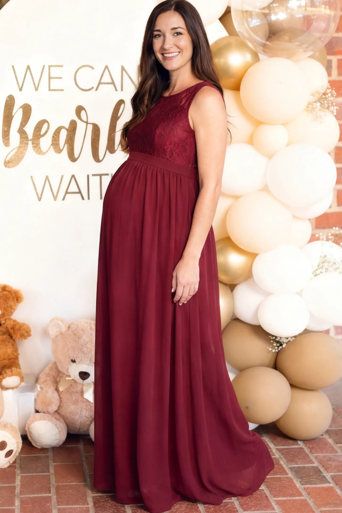 Floral Lace Sleeveless Maternity Maxi Dress in Burgundy featuring a flowing skirt on a pregnant model.