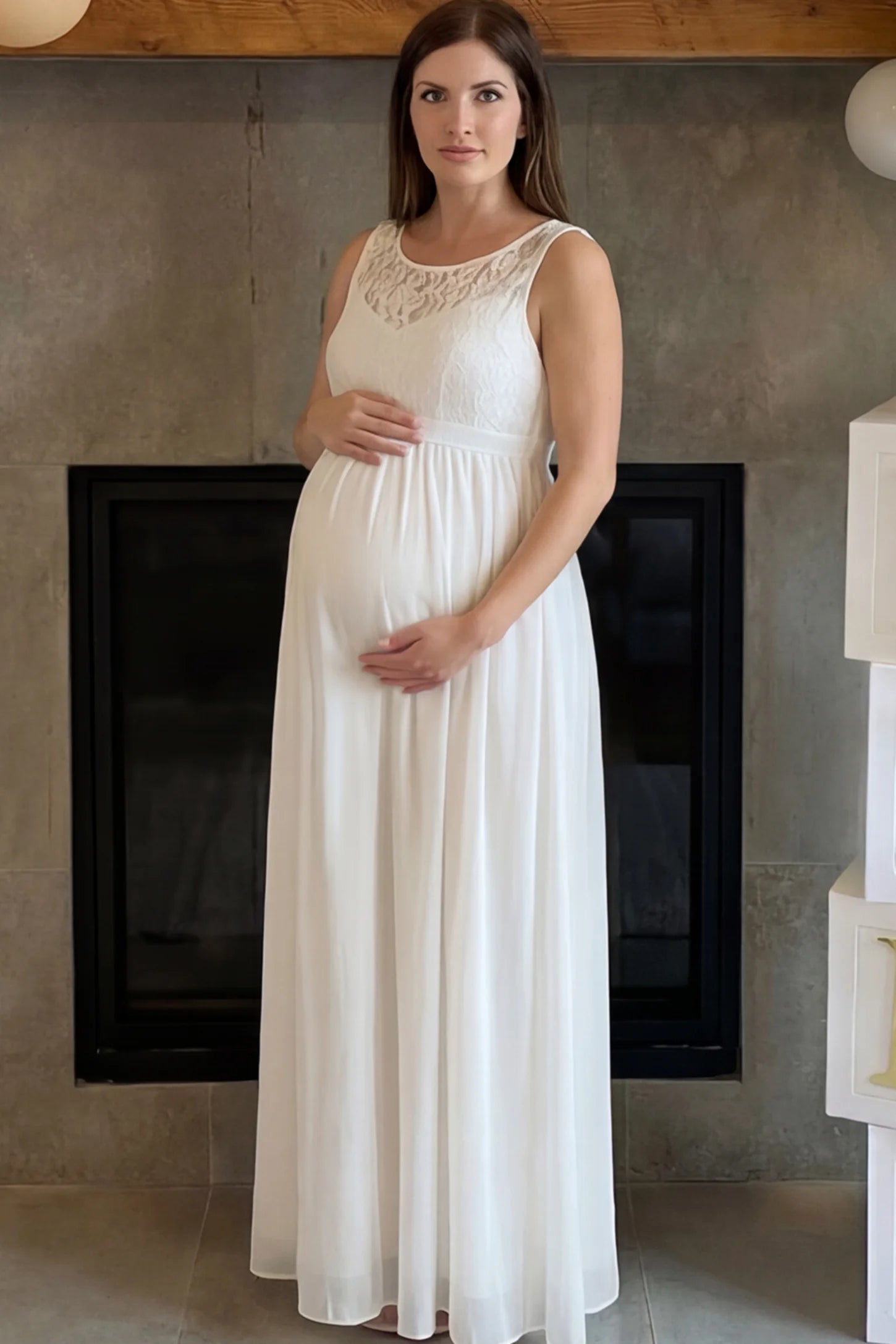 Floral Lace Sleeveless Maternity Maxi Dress Floral Lace Sleeveless Maternity Maxi Dress in White featuring a flowing skirt on a pregnant model.