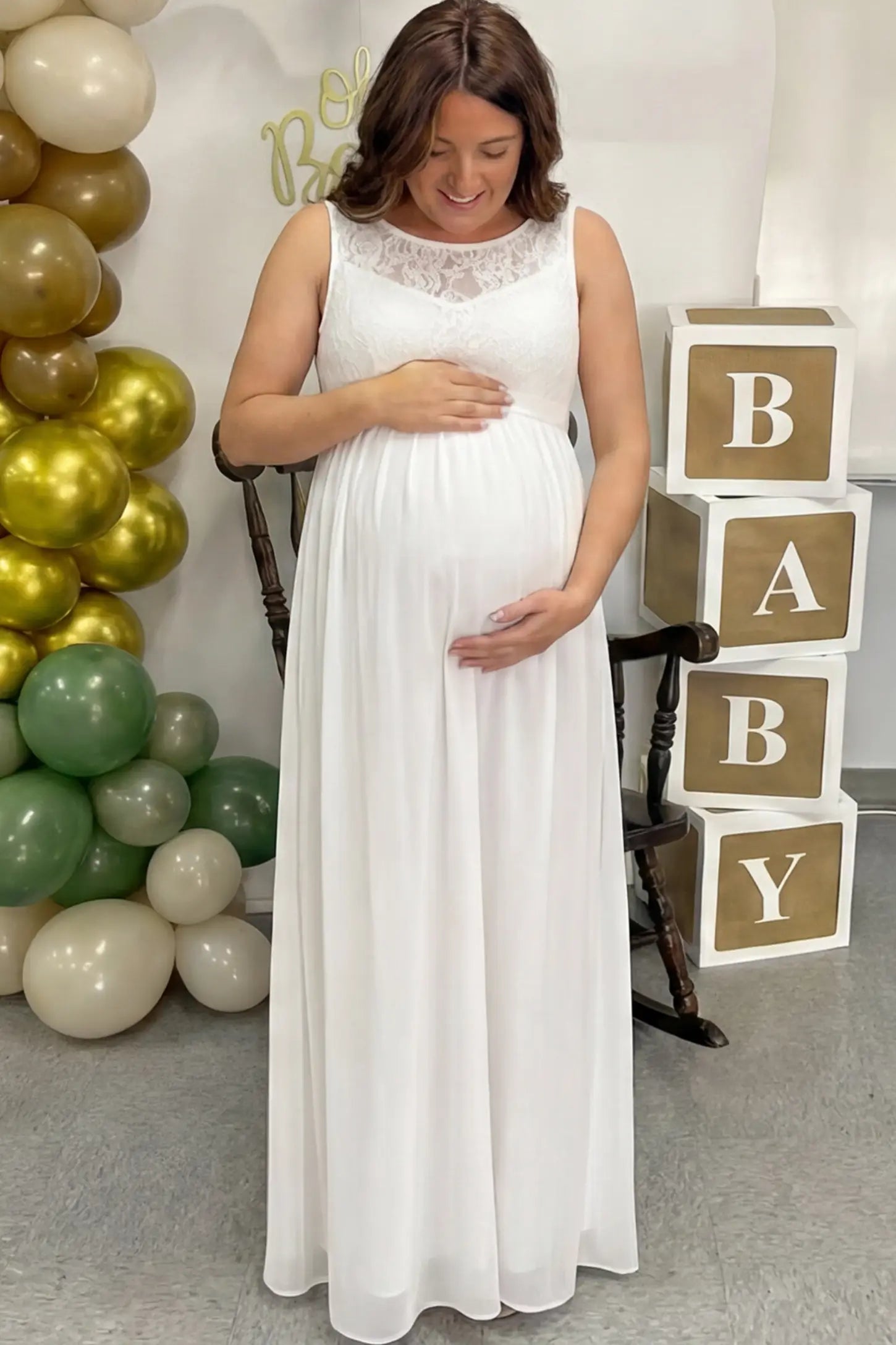 Floral Lace Sleeveless Maternity Maxi Dress Floral Lace Sleeveless Maternity Maxi Dress in White featuring a flowing skirt on a pregnant model.