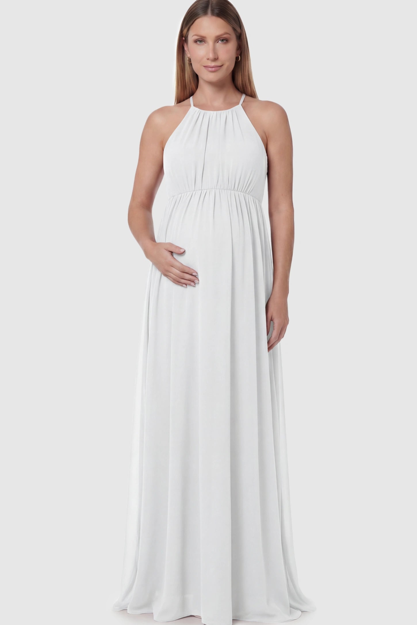 Pleated Mesh Sleeveless Maternity Photoshoot Dress Pleated Mesh Sleeveless Maternity Photoshoot Dress in White featuring a high-neckline and flowing skirt on a pregnant model.