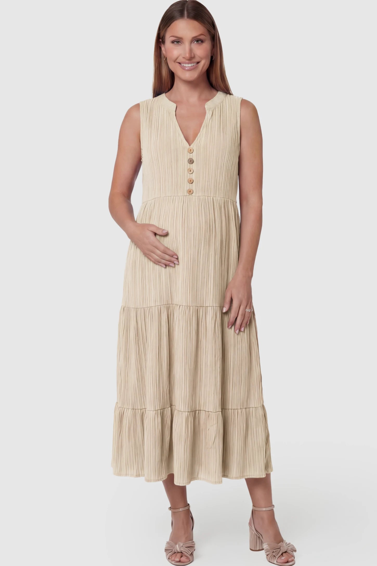 Solid Textured V-Neck Tiered Maternity Midi Dress Solid Textured V-Neck Tiered Maternity Midi Dress in Apricot featuring a high-waisted A-line silhouette on a pregnant model.