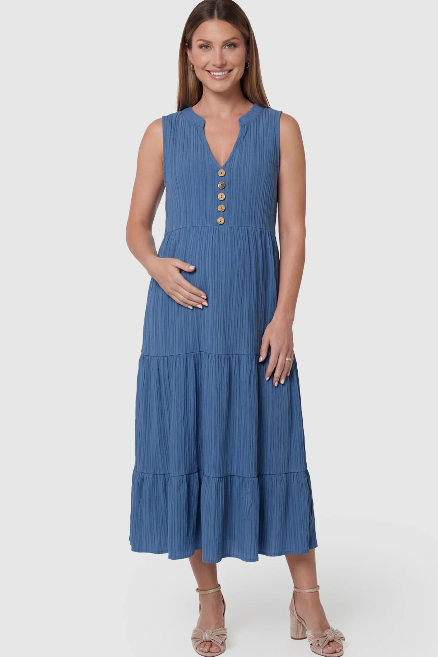 Solid Textured V-Neck Tiered Maternity Midi Dress Solid Textured V-Neck Tiered Maternity Midi Dress in Blue featuring a high-waisted A-line silhouette on a pregnant model.
