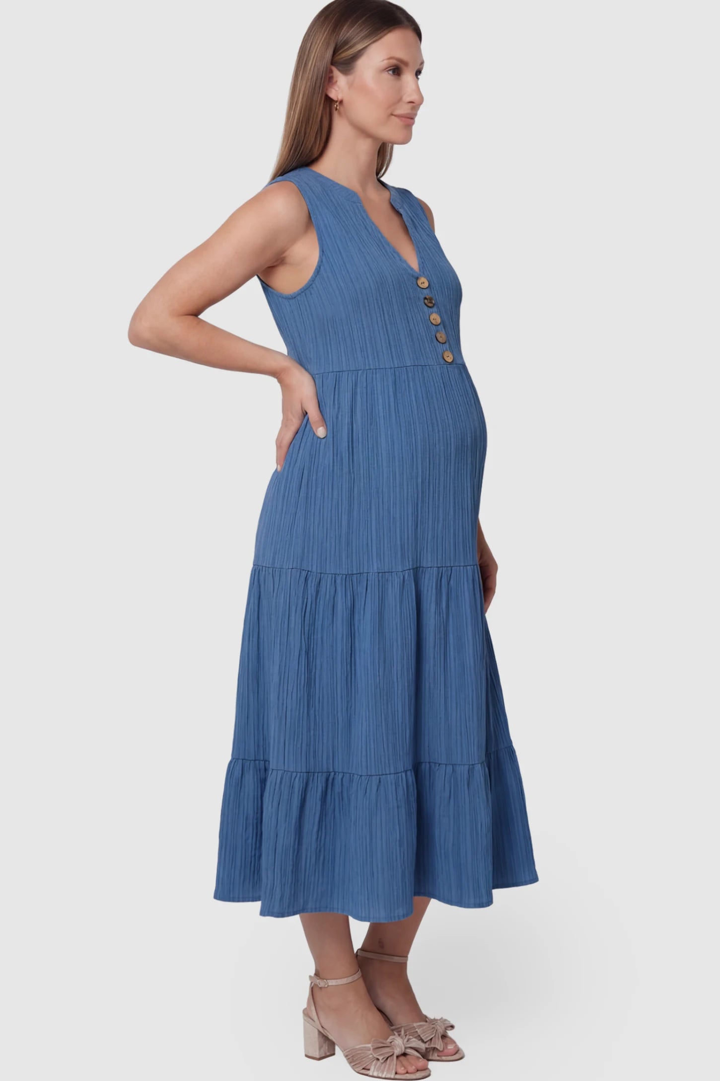 Solid Textured V-Neck Tiered Maternity Midi Dress Solid Textured V-Neck Tiered Maternity Midi Dress in Blue featuring a high-waisted A-line silhouette on a pregnant model.