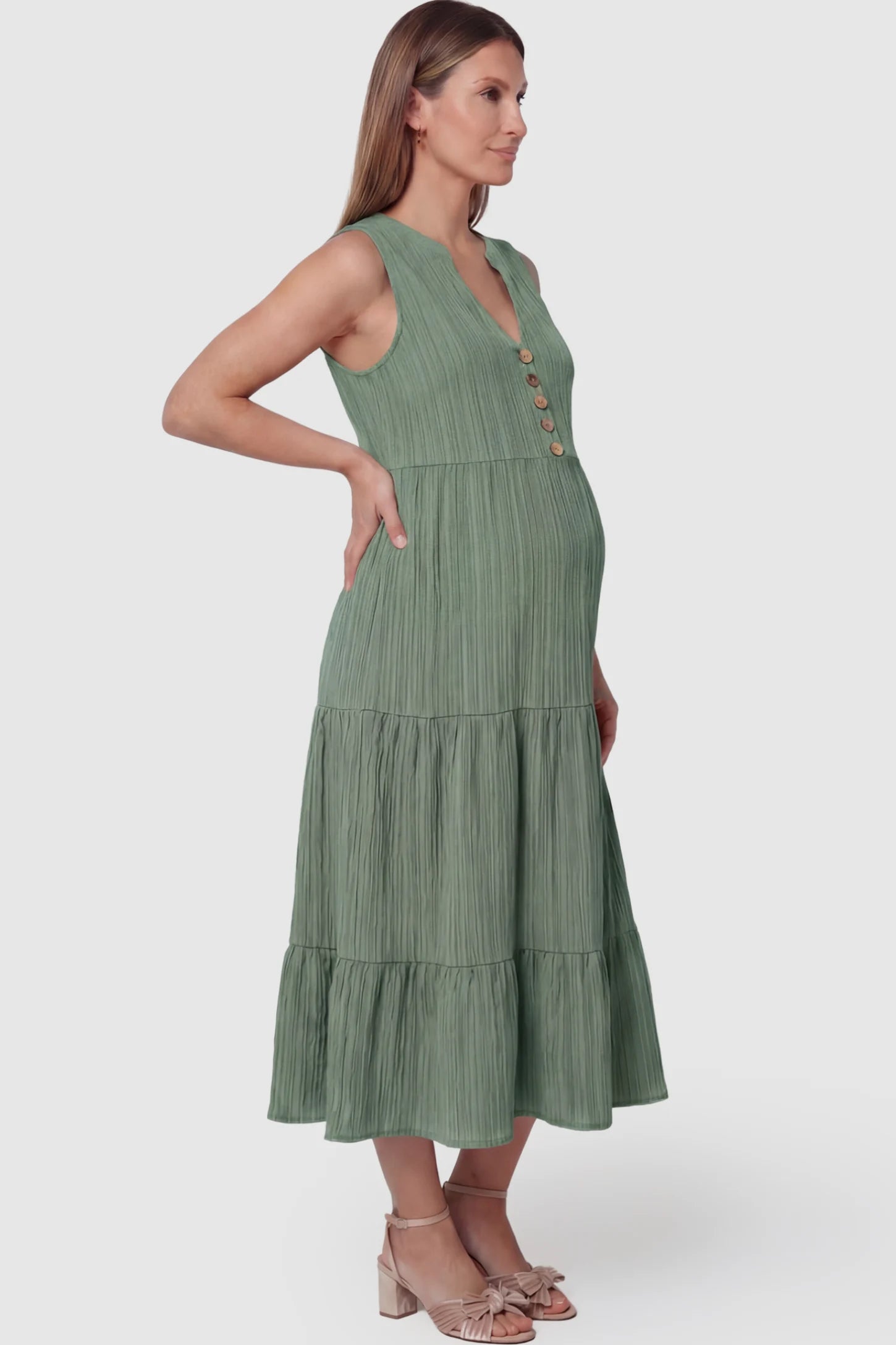 Solid Textured V-Neck Tiered Maternity Midi Dress Solid Textured V-Neck Tiered Maternity Midi Dress in Green featuring a high-waisted A-line silhouette on a pregnant model.